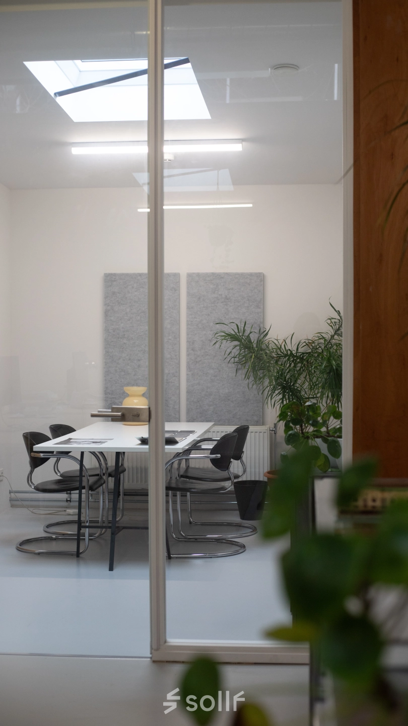 Modern office space at Hondiusstraat 7H in Amsterdam West, featuring a sleek conference room with a white table, black chairs, and minimalist decor. Ideal for office space rental.