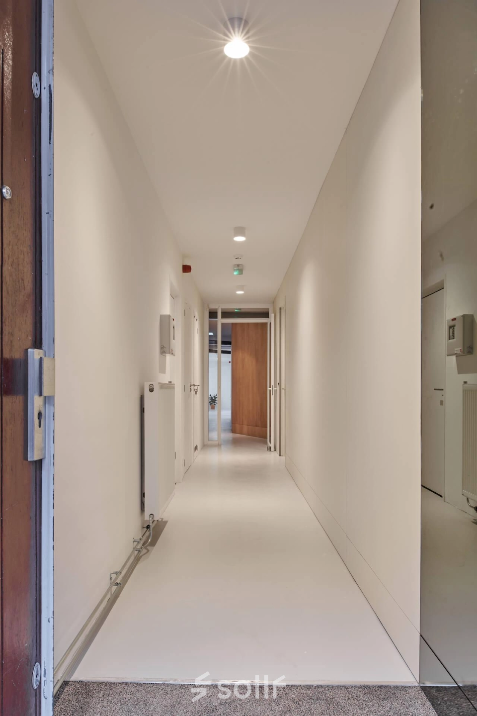 Bright, well-lit corridor in an office building located at Hondiusstraat 7H, Amsterdam West, ideal for seamless office space rental with modern design elements.