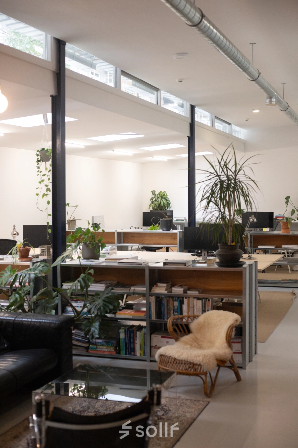Spacious and modern office interior at Hondiusstraat 7H in Amsterdam West, featuring stylish furnishings, plants, and multiple workstations. Ideal for those seeking office space rental in a vibrant location.