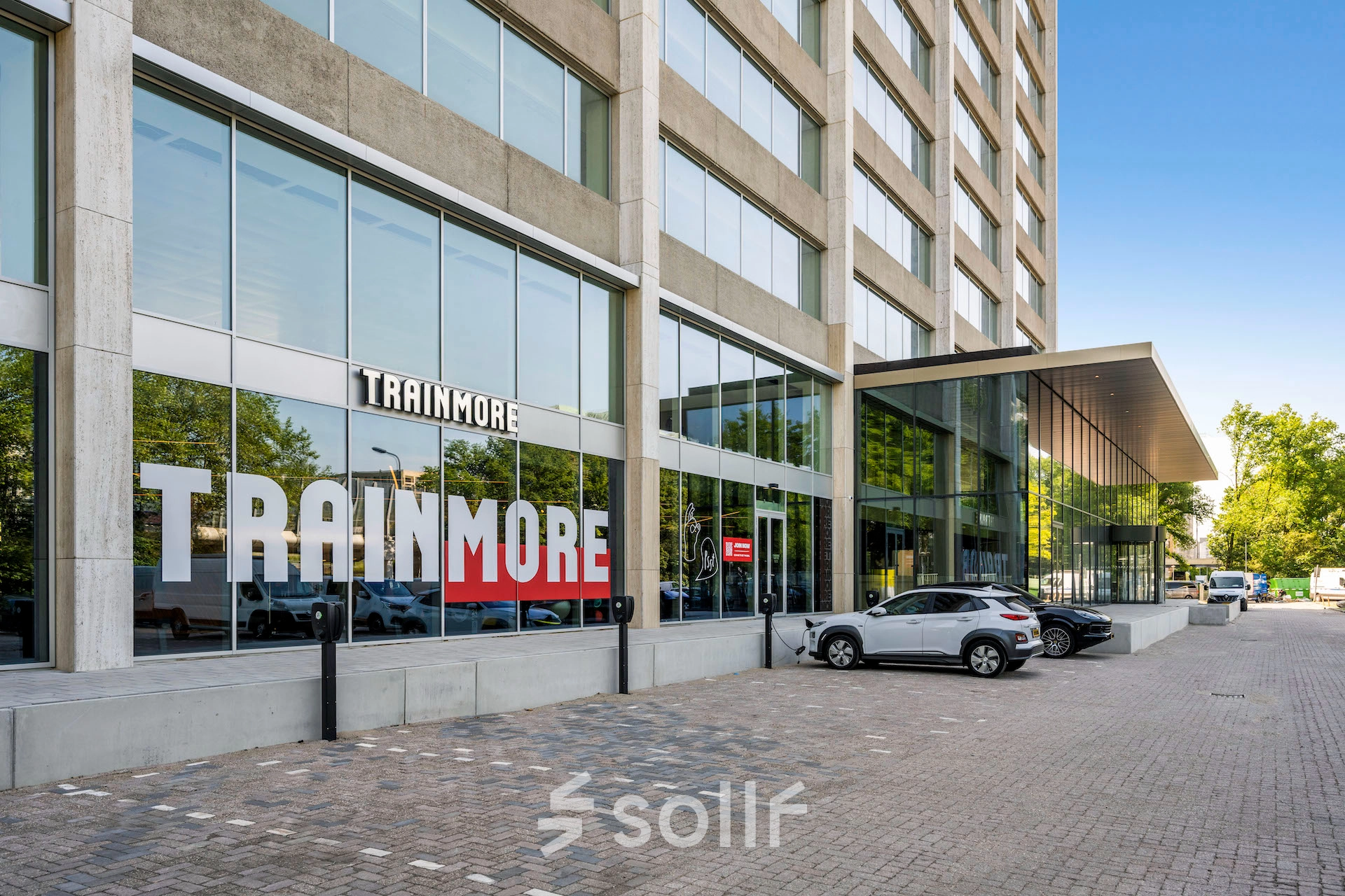 Exterior view of an office building at Nachtwachtlaan 20 in Amsterdam West, showing the street entrance and parking area for office space rental.