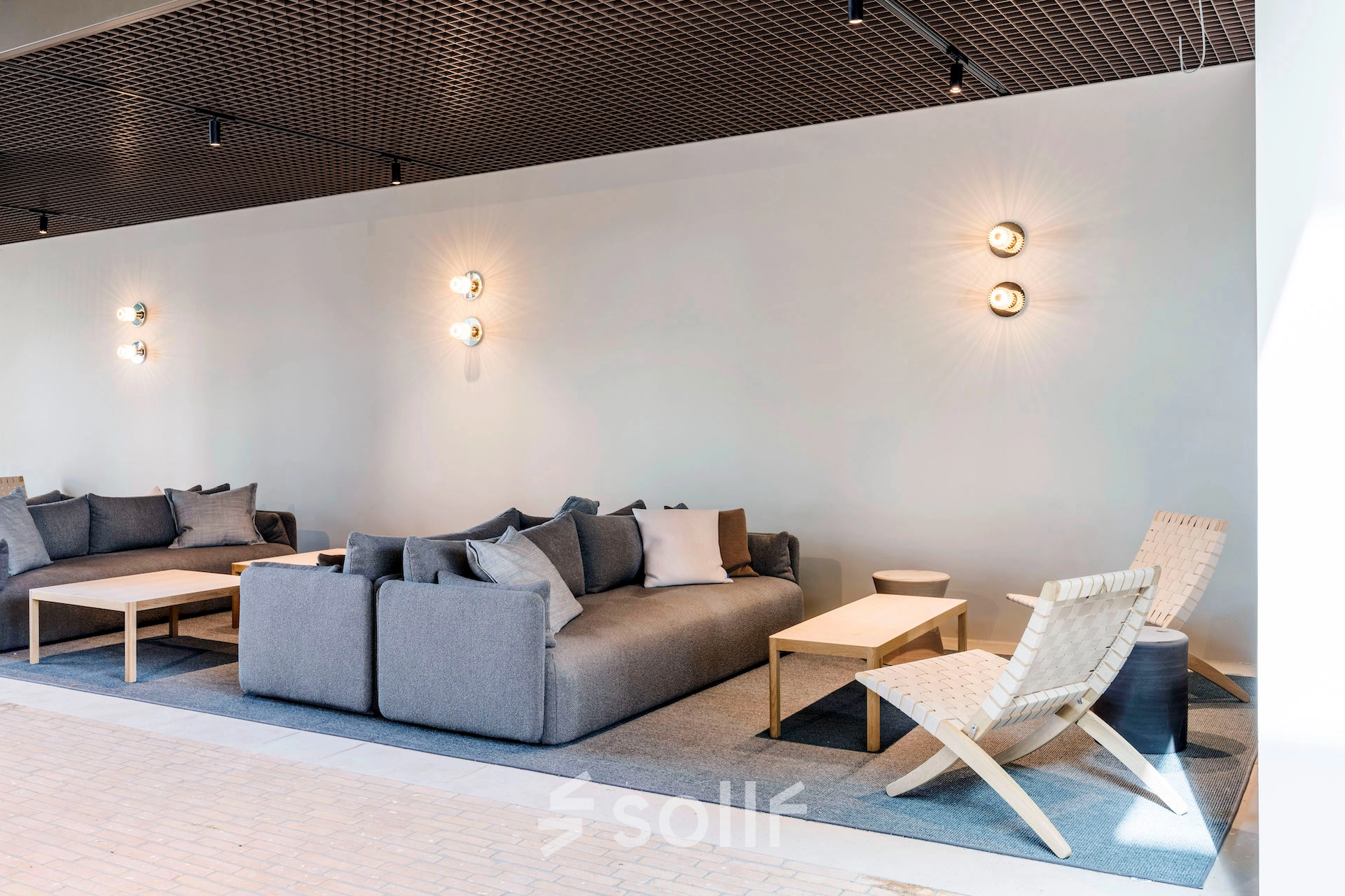 Stylish office lounge in Amsterdam West featuring modern seating and soft lighting, offering comfortable space for work or meetings. Ideal for office space rental.