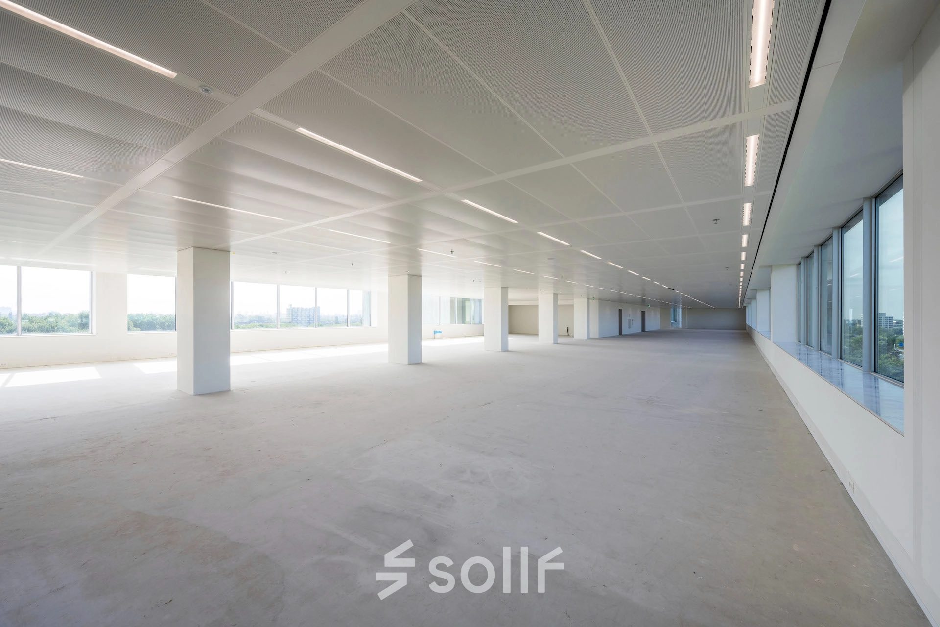 Office space for rent at Nachtwachtlaan 20, Amsterdam West. Spacious, unfurnished interior with large windows providing natural light, ideal for various office setups.