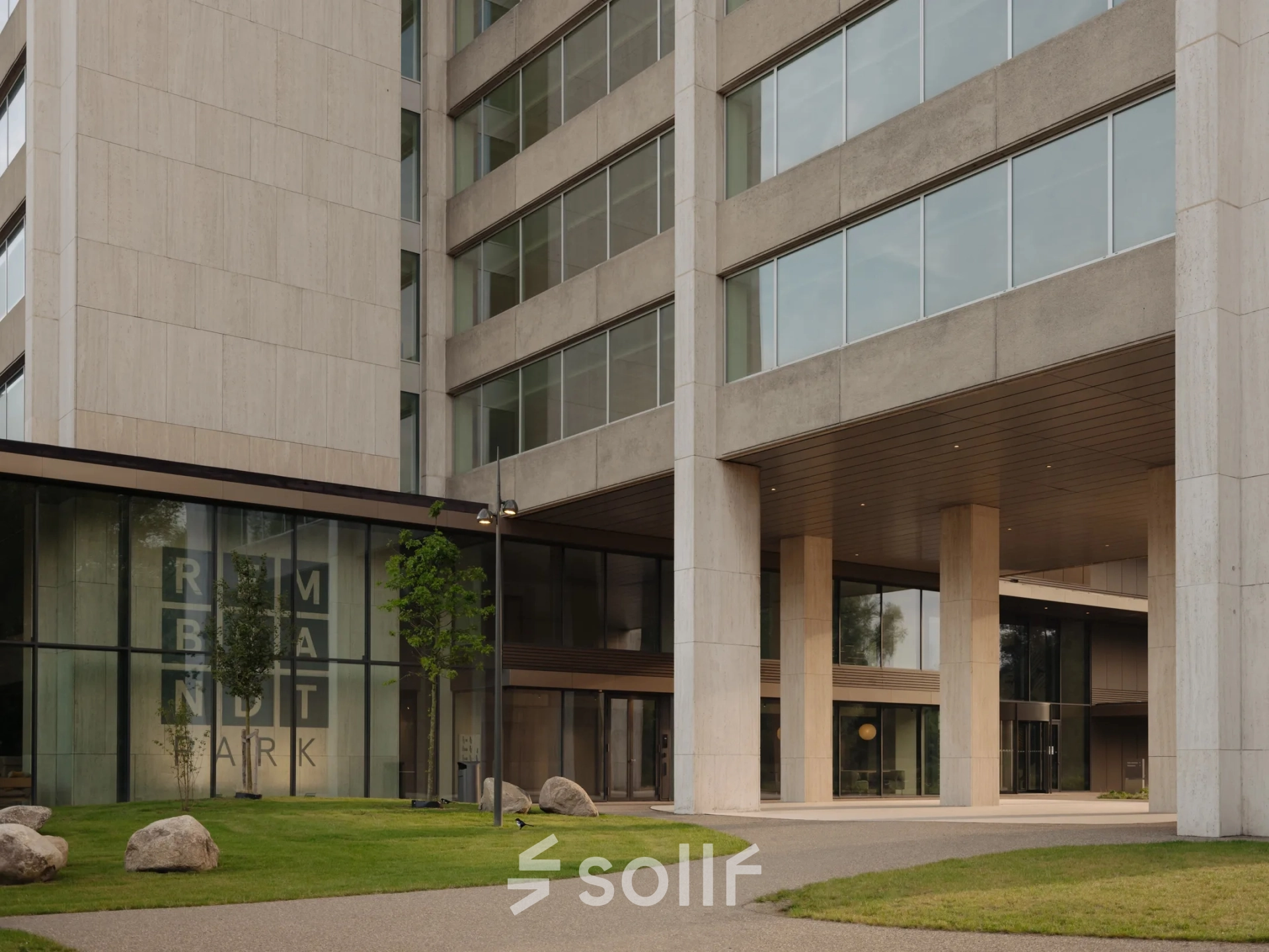 Exterior view of an office building at Nachtwachtlaan 20, Amsterdam West. The entrance features large glass windows and a modern facade, ideal for office space rental.