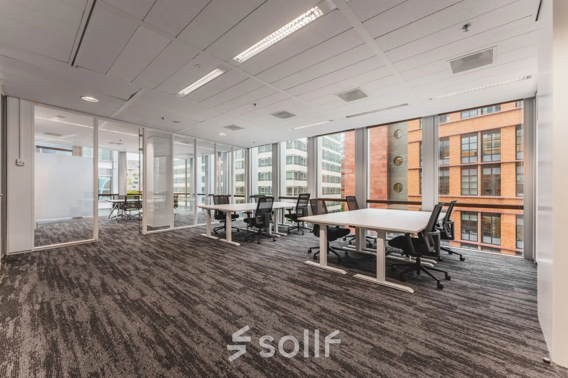 Spacious office interior at Claude Debussylaan 10 in Amsterdam Zuidas with modern furnishings and large windows, ideal for office space rental.