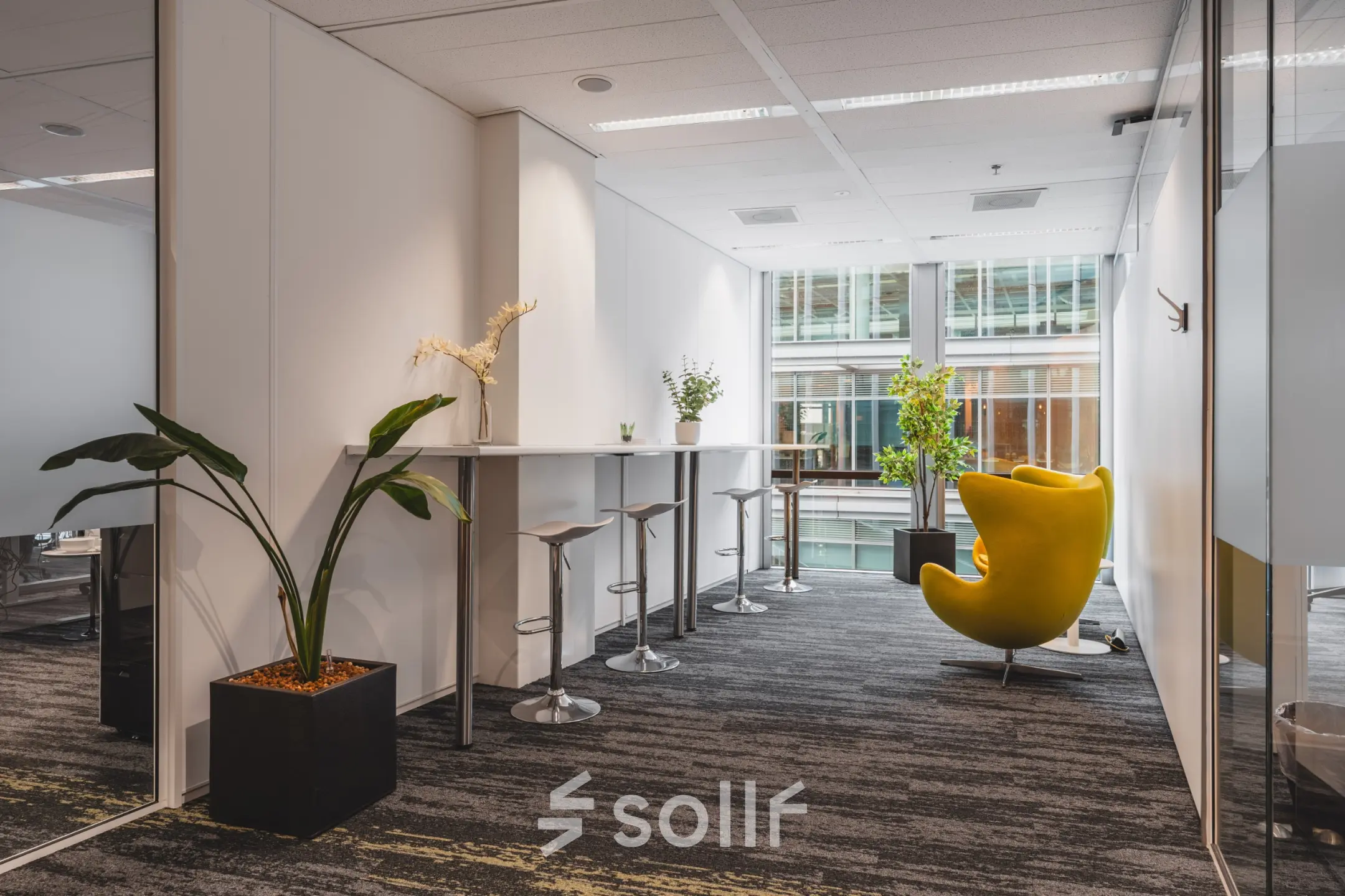 Furnished office space for rent at Claude Debussylaan 10, Amsterdam Zuidas, with modern seating and plants creating a welcoming atmosphere.