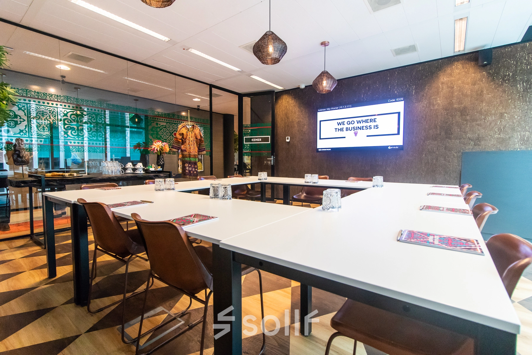 Modern conference room at Claude Debussylaan 7-29, Amsterdam Zuidas, featuring stylish decor, long tables, and a wall-mounted screen. Ideal for office space rental.