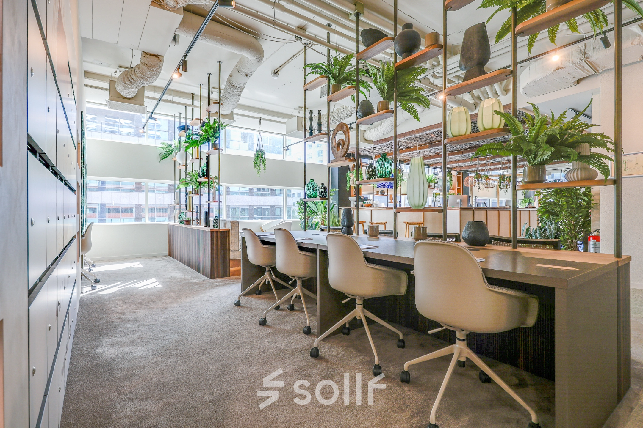 Bright and welcoming office space for rent at Gustav Mahlerlaan 308, Amsterdam Zuidas, featuring modern furnishings and open workstations with natural light and green accents.