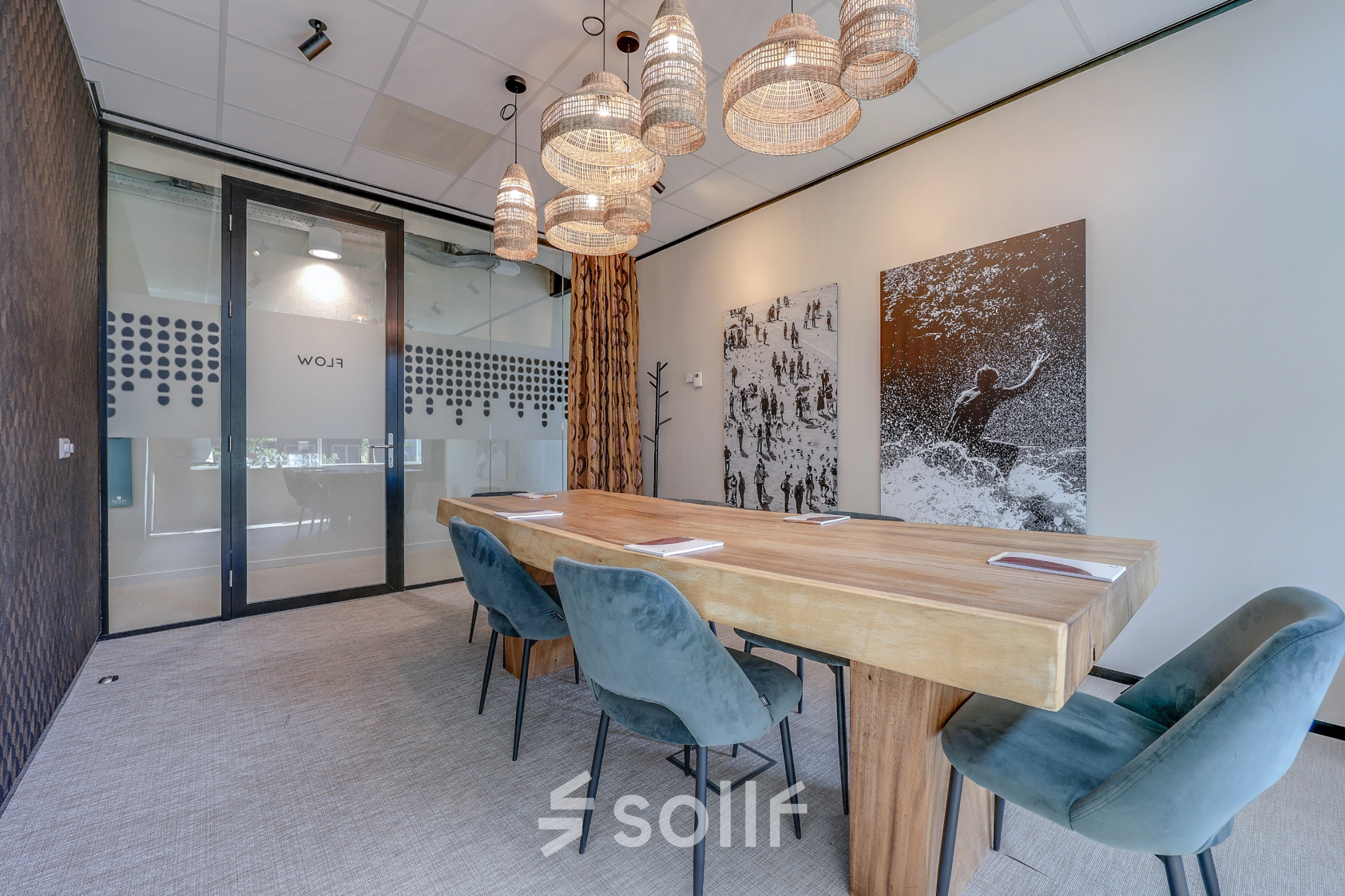 Modern conference room at Gustav Mahlerlaan 308, Amsterdam Zuidas, featuring a large wooden table, comfortable chairs, and artistic wall decor offers an ideal office space rental opportunity.