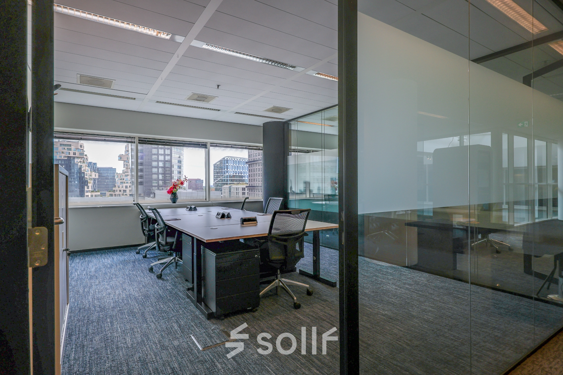 Modern office space at Gustav Mahlerplein in Amsterdam Zuidas, featuring a furnished interior with desks and chairs, available for rent.