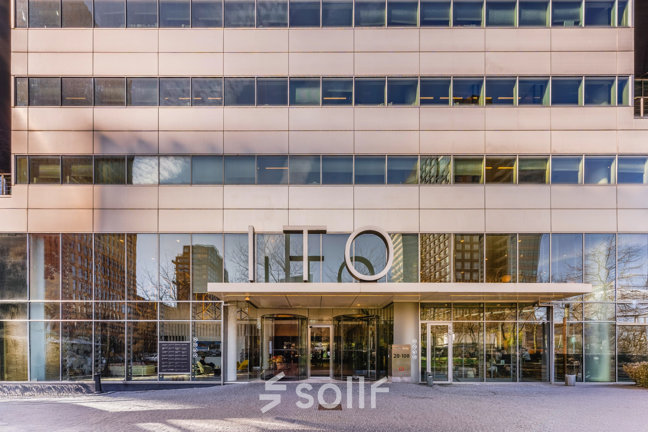 Exterior view of office building at Gustav Mahlerplein 28 & 58-60 in Amsterdam Zuidas, showcasing large glass windows and a modern facade.