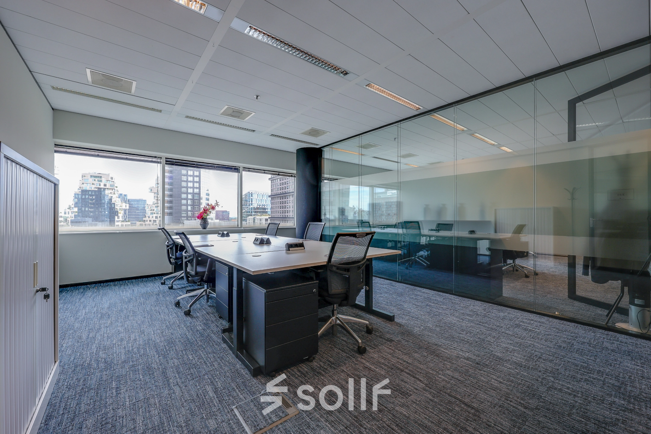 Modern office space with large windows, furnished with sleek desks and chairs, located at Gustav Mahlerplein in Amsterdam Zuidas, ideal for rent office space.