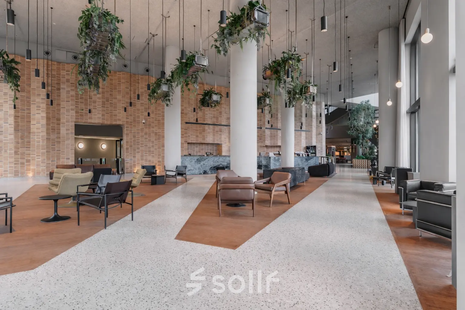 Spacious, modern office lounge with stylish furnishings and suspended greenery in Amsterdam Zuidas. An ideal office space rental opportunity at Hildegard Von Bingenstraat 44.