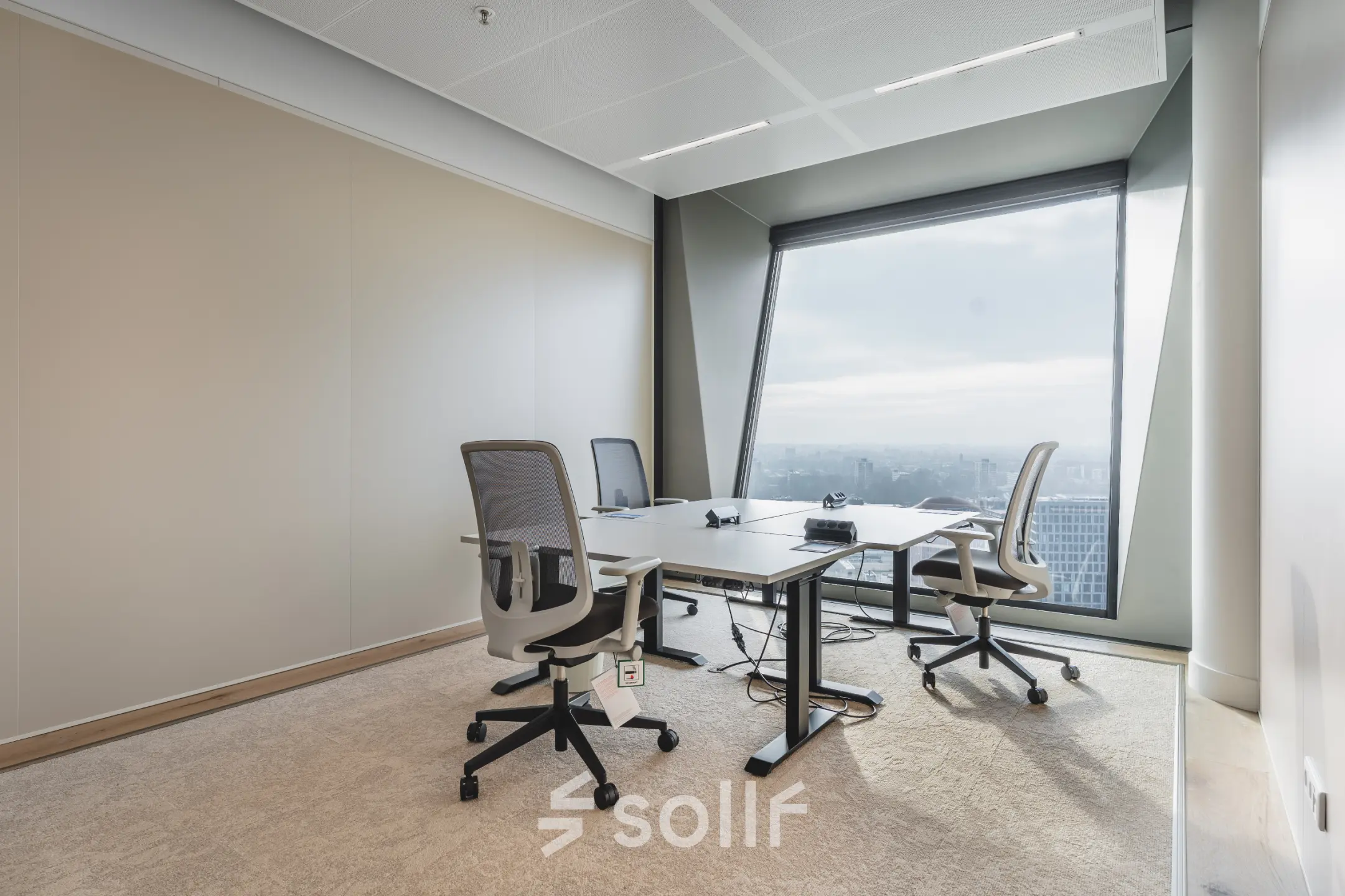 Bright office space for rent at Hildegard Von Bingenstraat 44 in Amsterdam Zuidas with sleek furnishings, featuring a large window and modern desks.
