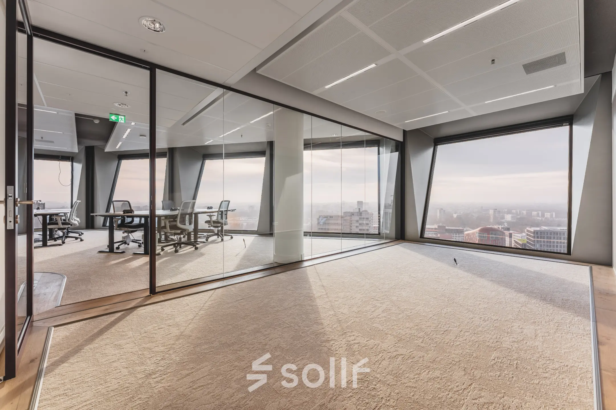 Modern office space for rent at Hildegard Von Bingenstraat 44, Amsterdam Zuidas, featuring large windows with city views and a glass-walled meeting room.