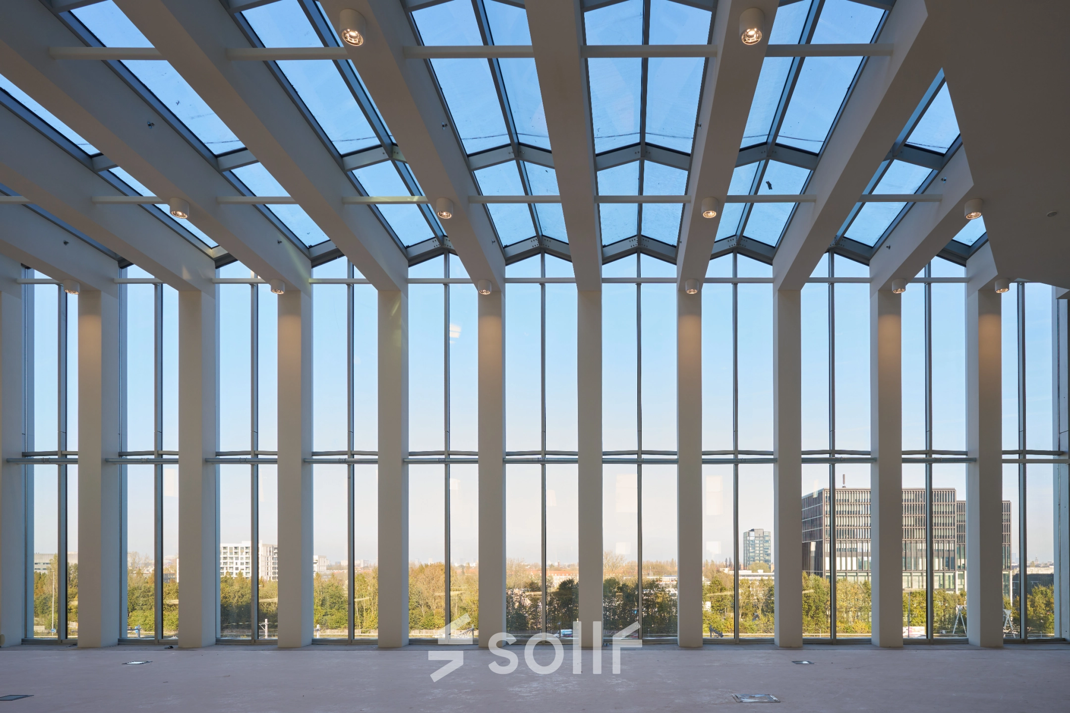 Spacious office space available for rent in Amsterdam Zuidas, featuring large windows with stunning views and abundant natural light.