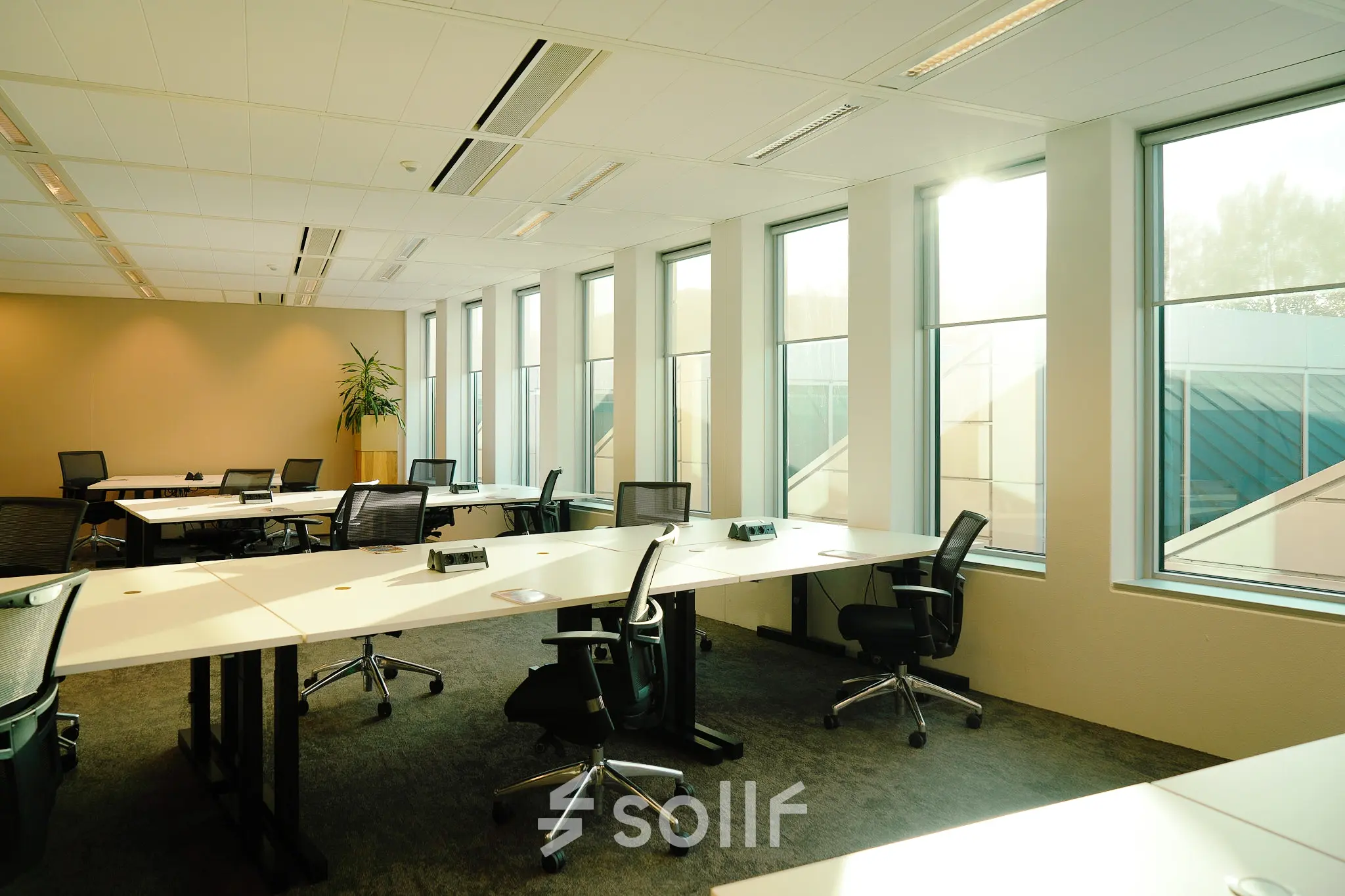 Bright office space at Jachthavenweg 109 in Amsterdam Zuidas, featuring large windows and multiple desks. Ideal for businesses seeking office space rental.