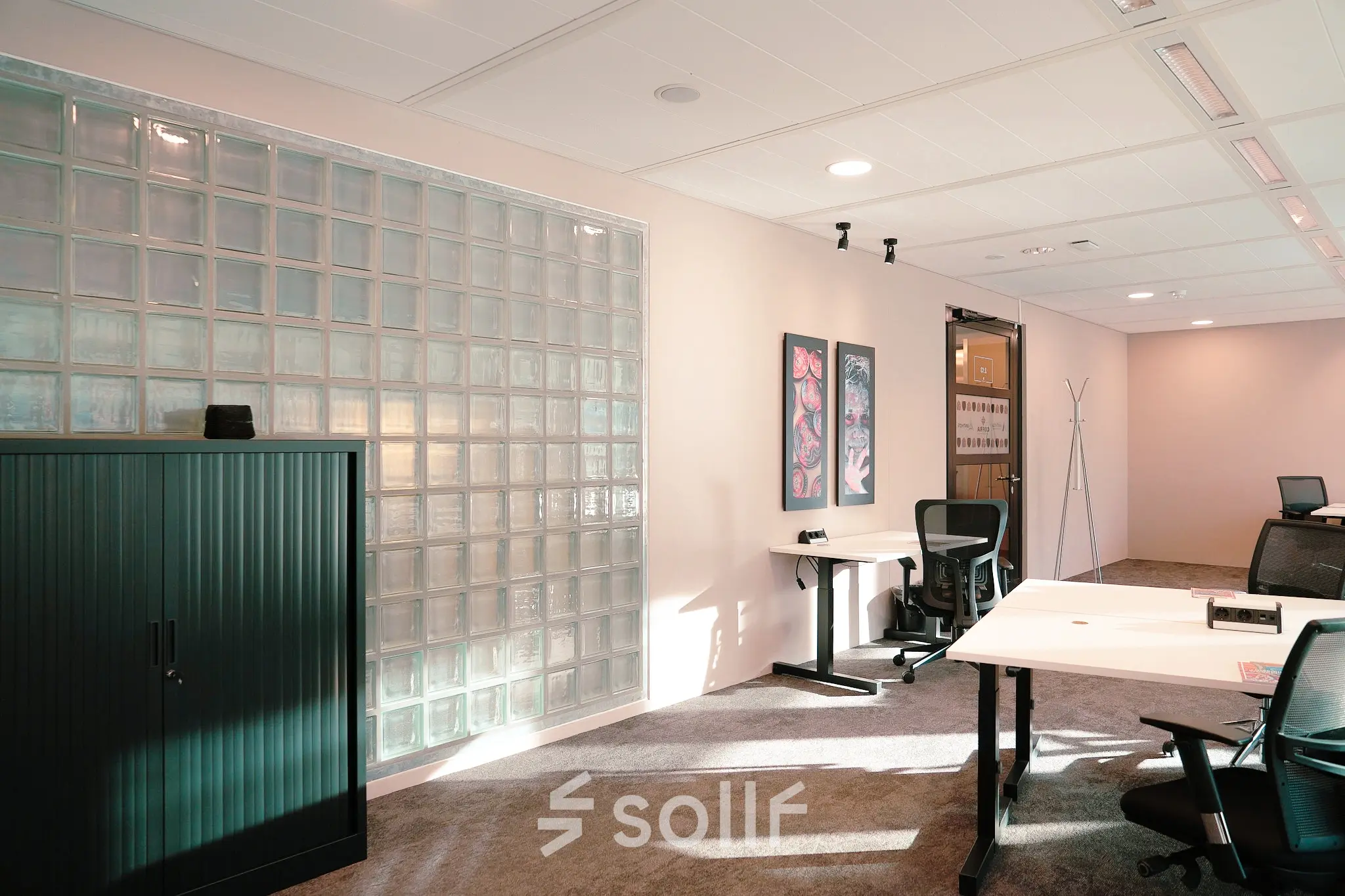 Modern office space at Jachthavenweg 109, Amsterdam Zuidas, featuring glass partition, desks, and office chairs, ideal for rent office space.