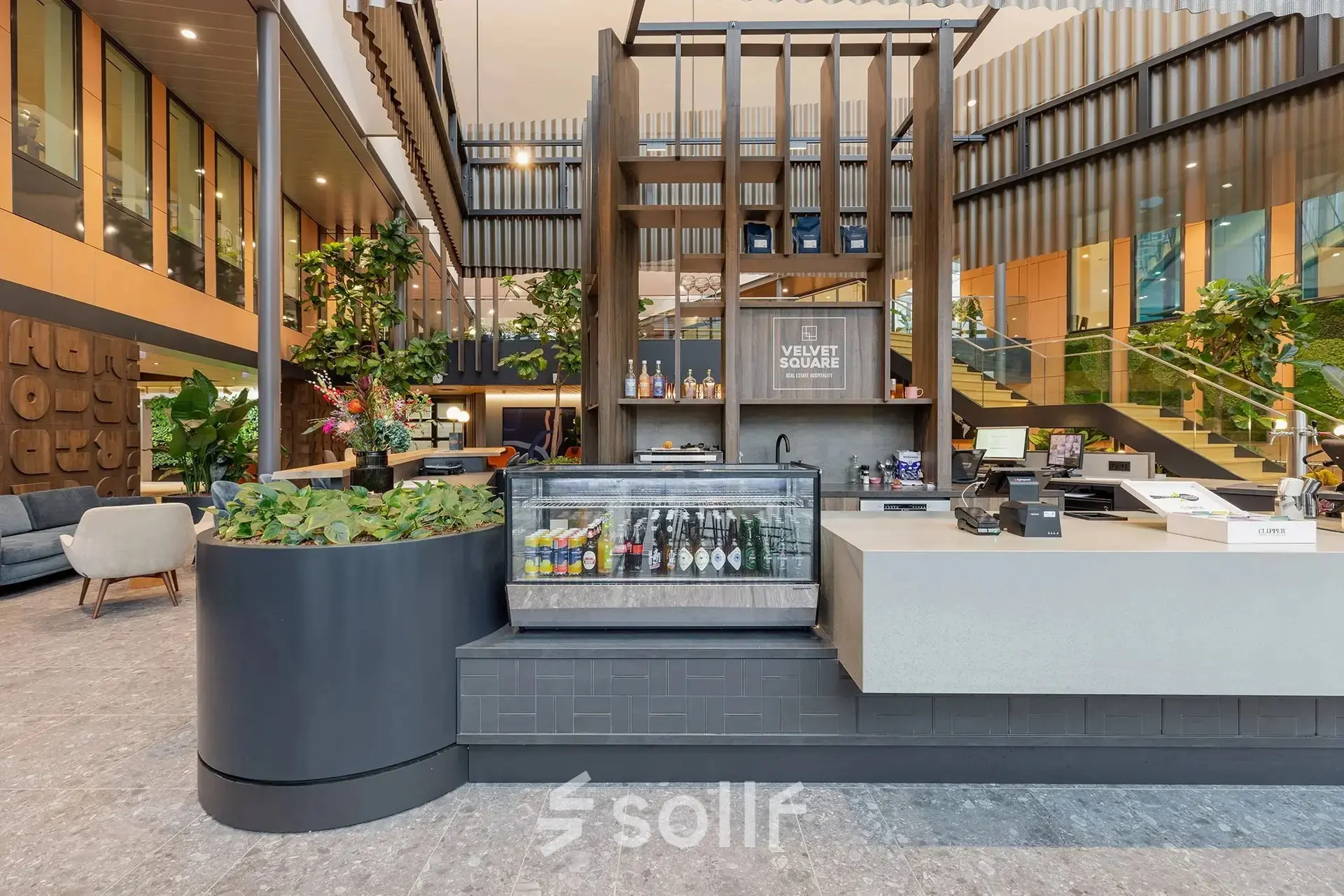 Modern office space at Jachthavenweg 109 in Amsterdam Zuidas featuring a stylish reception area with a beverage cooler and plants, ideal for those seeking office space rental.
