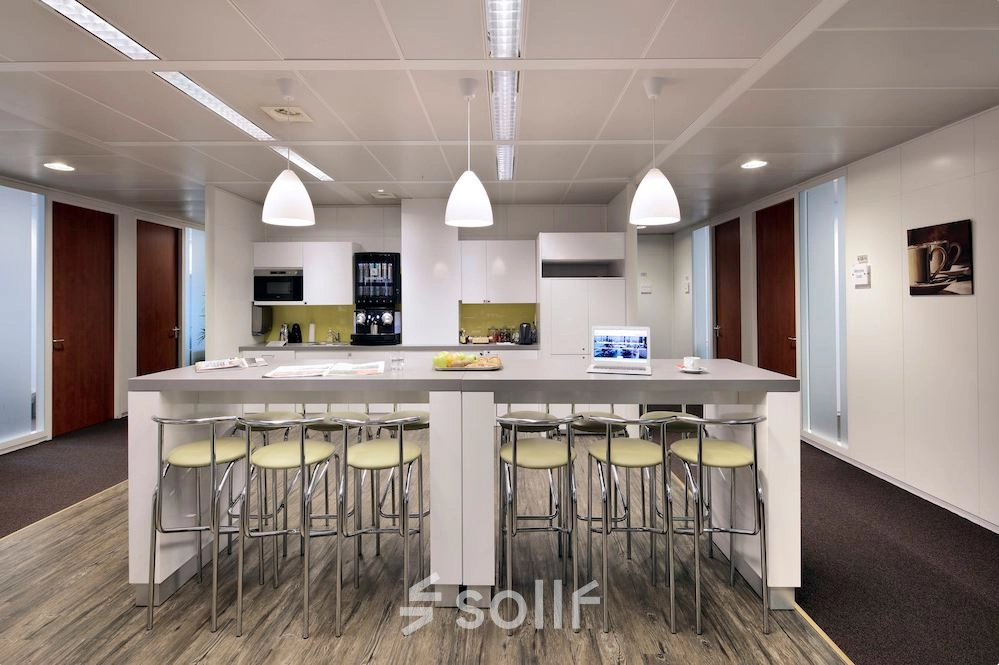Modern office kitchen space at Lange Lozanastraat 142 in Antwerp Center, featuring a sleek counter with bar stools, ideal for office space rental.