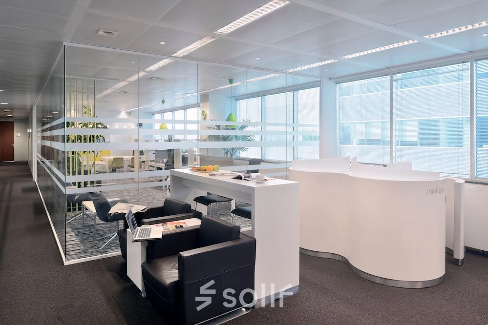 Modern office space in Antwerp with sleek furniture and glass partitions, ideal for business activities. Find office space rental opportunities here.