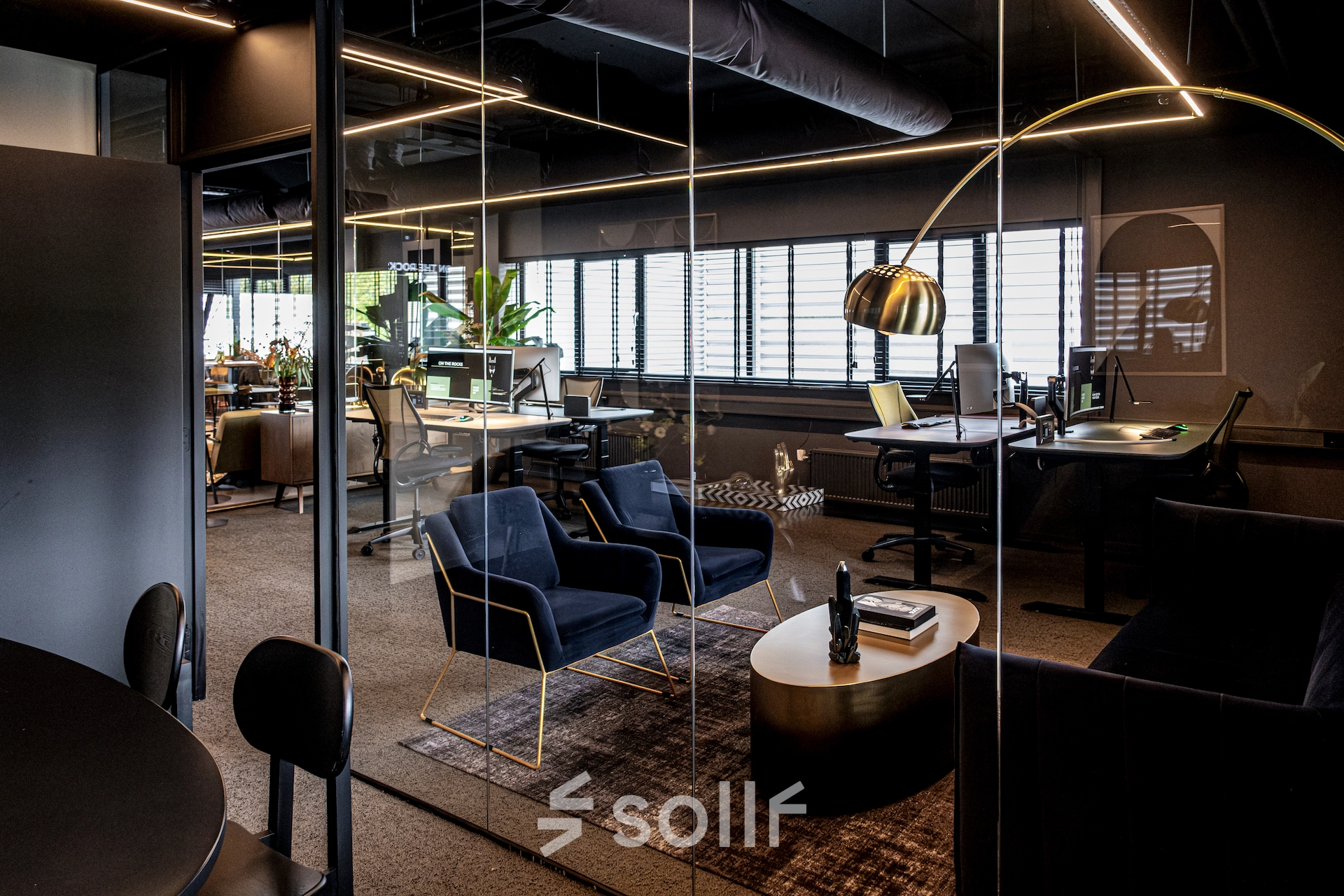 Modern office space in Apeldoorn with stylish furnishings, glass walls, and desks set up for work. Ideal for those looking to rent office space or interested in office space rental.