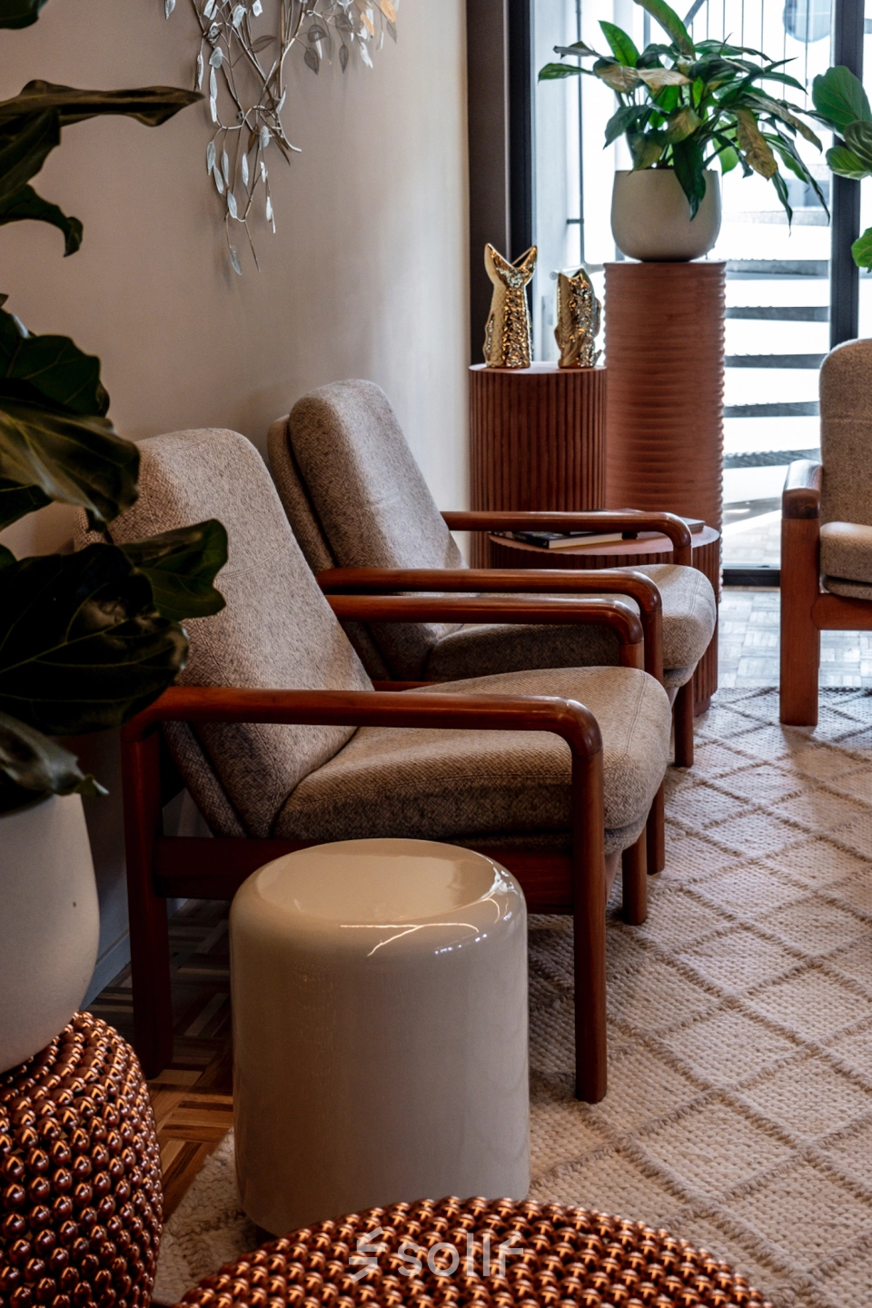 Cozy waiting area with comfortable chairs, decorative plants, and stylish tables at an office to rent in Lange Amerikaweg, Apeldoorn.