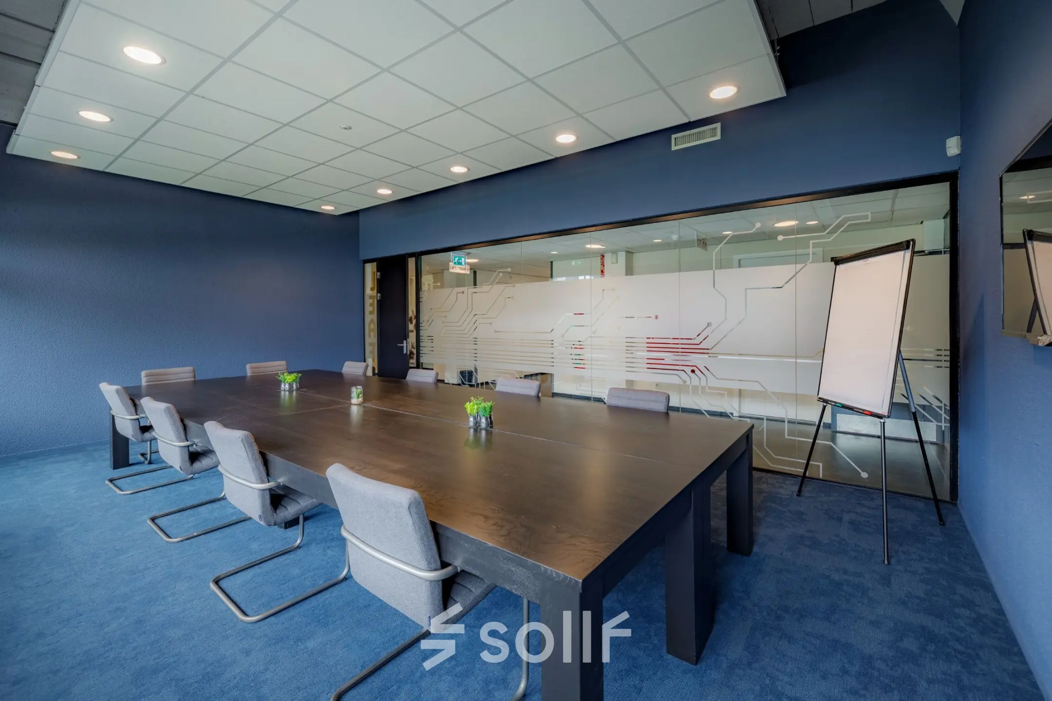 Modern conference room with a large table and chairs, featuring a blue color scheme at Oude Apeldoornseweg 41-45, ideal for office space rental.