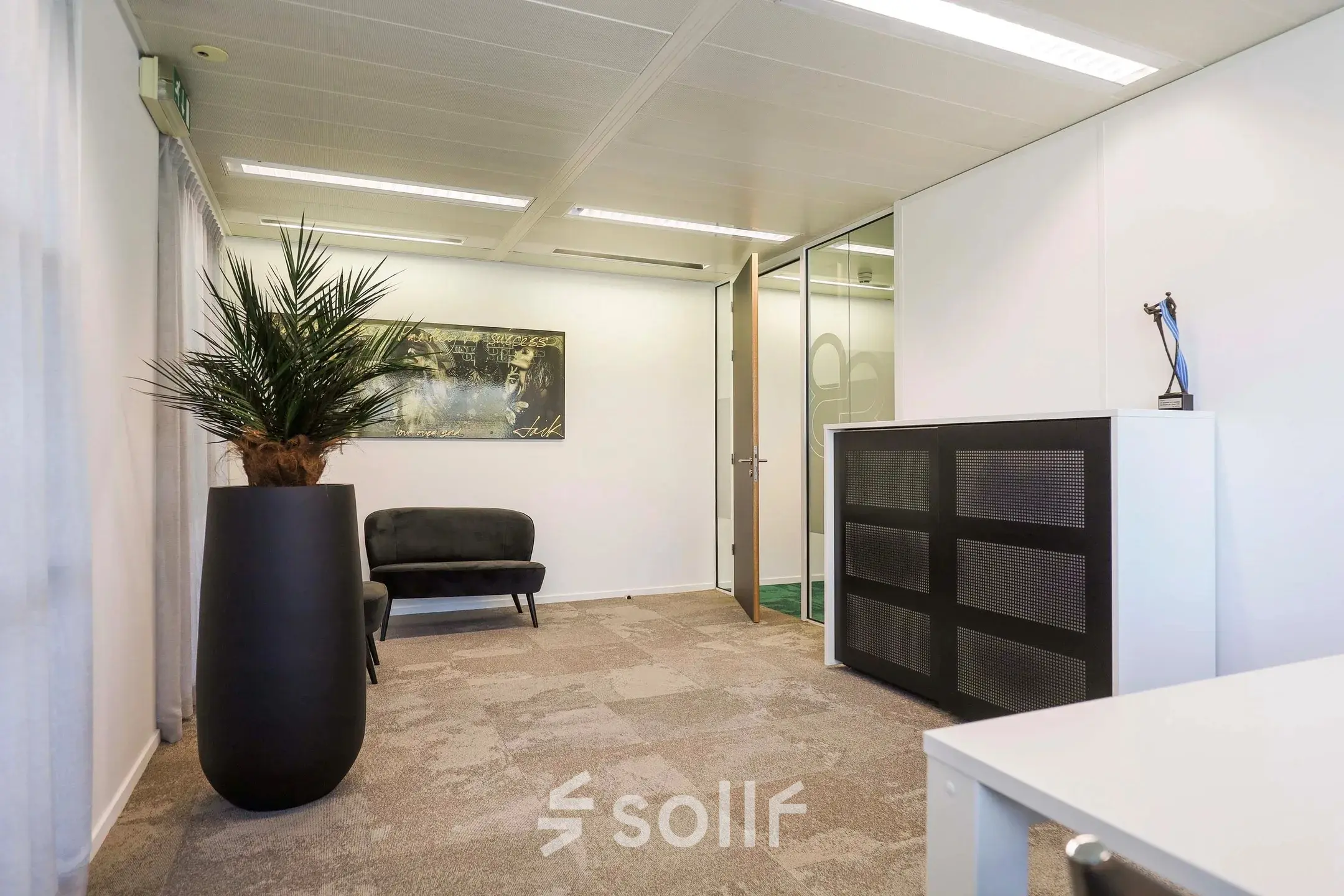 Office space at Prins Willem-Alexanderlaan 301 in Apeldoorn, featuring modern decor with a large plant and artwork, suitable for office space rental.