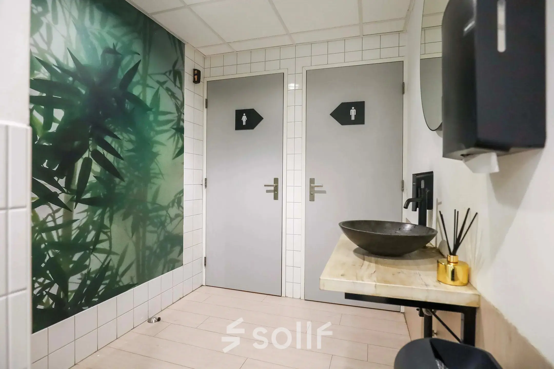 Interior view of a restroom with a modern sink, stylish wallpaper, and tiled walls at an office to rent in Prins Willem-Alexanderlaan 301, Apeldoorn.