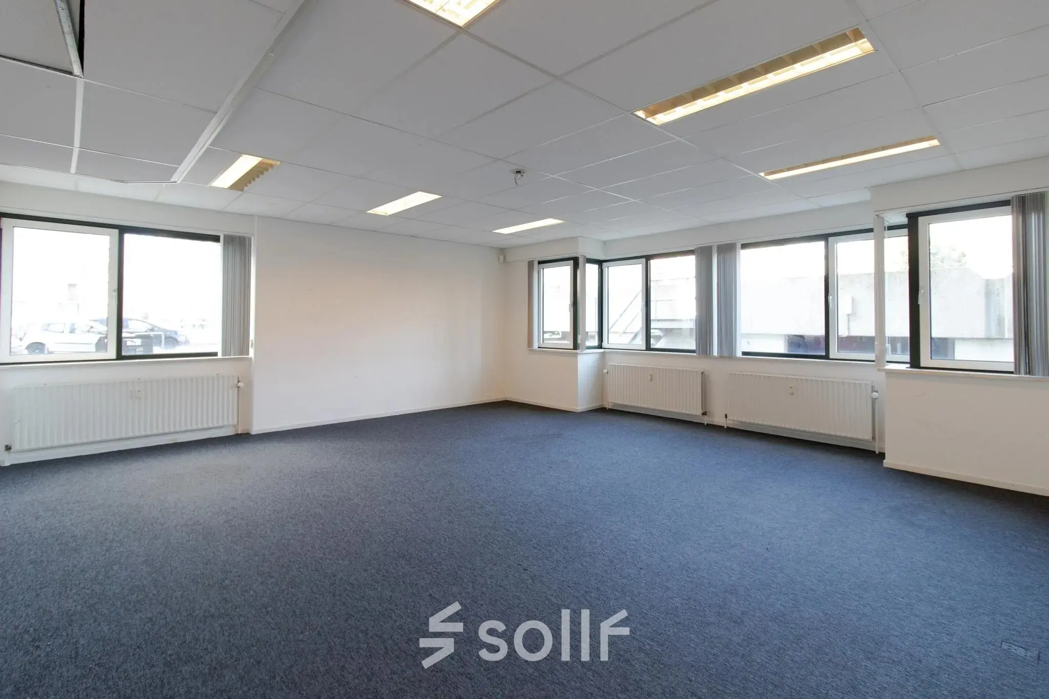 Spacious unfurnished office to rent at Prins Willem-Alexanderlaan 401, Apeldoorn with large windows and carpeted floors, perfect for office space rental.