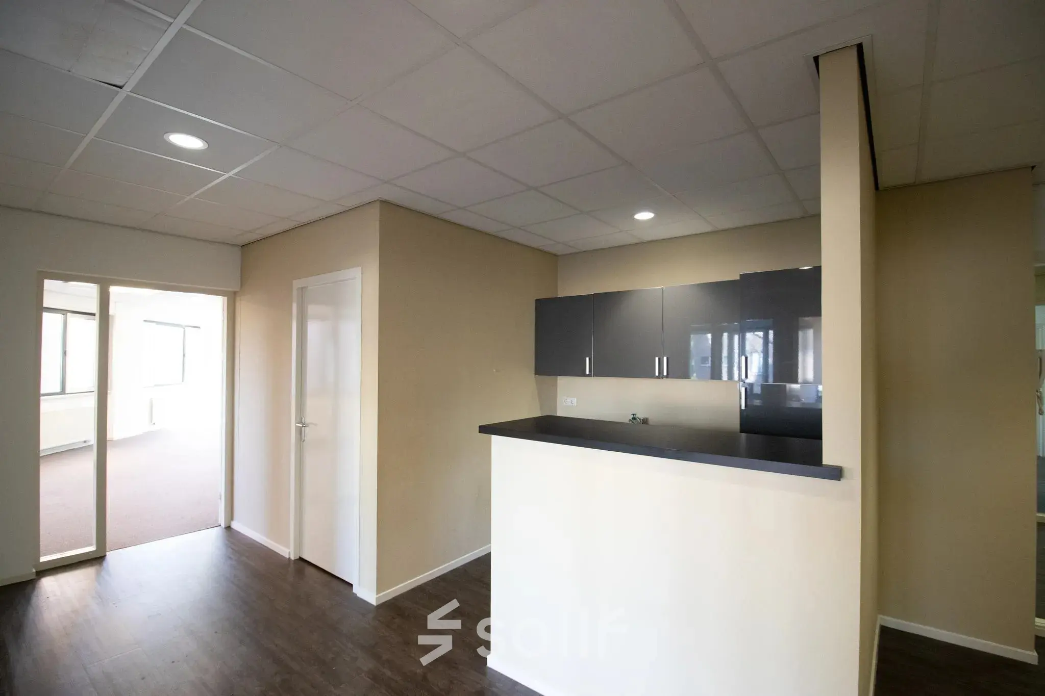 Interior view of an office space at Prins Willem-Alexanderlaan 401 in Apeldoorn. The office features a small counter and spacious layout, suitable for office space rental.