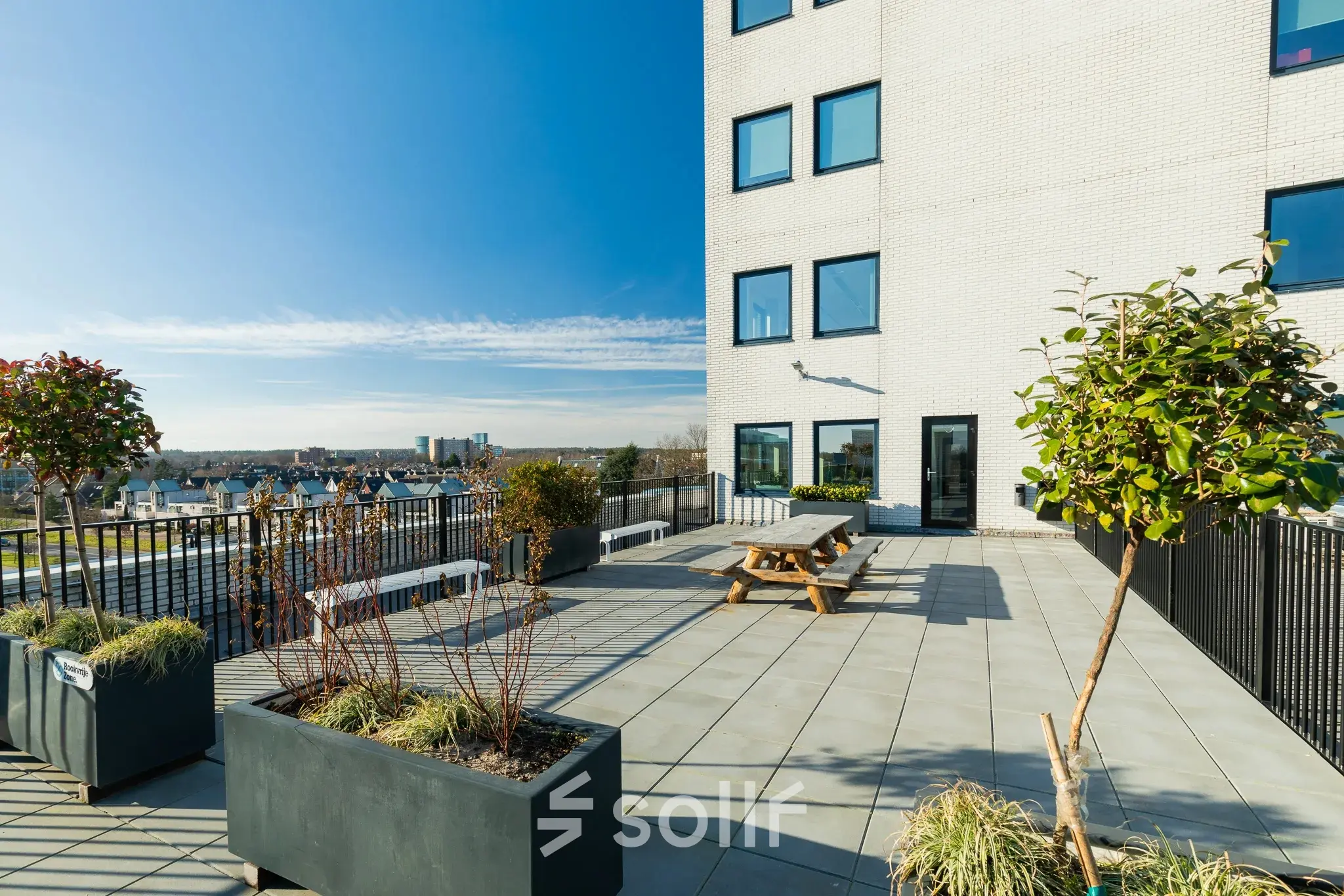 Sunny outdoor terrace at Prins Willem Alexanderlaan 701 in Apeldoorn, ideal for office space rental with views of the cityscape.