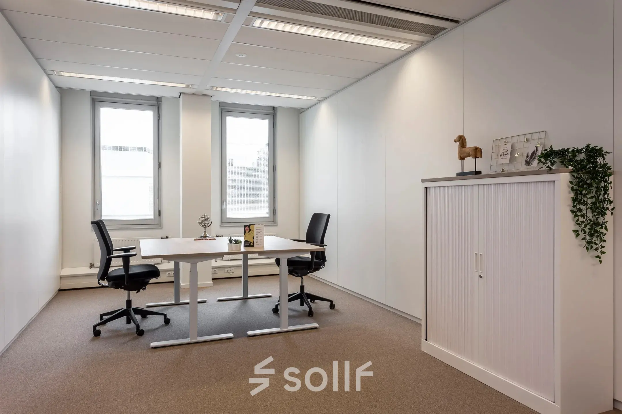 Bright office to rent at Roggestraat 111, Apeldoorn, featuring modern desks, chairs, and a storage cabinet by the window.