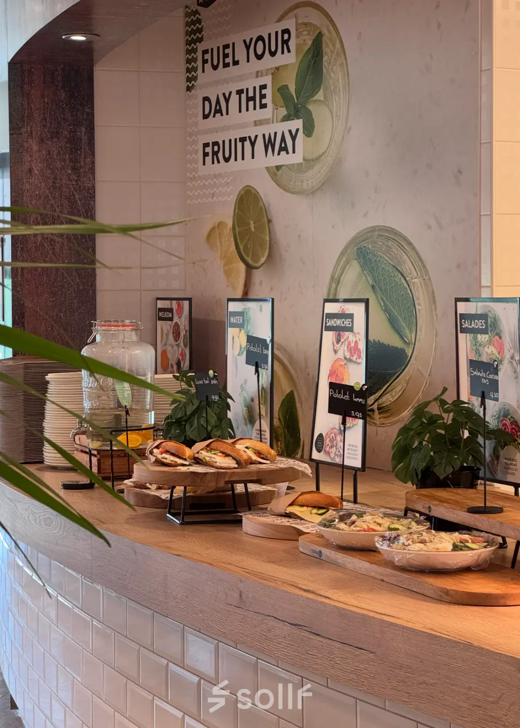 Inviting cafeteria area in Apeldoorn's Schumanpark 9, perfect for taking a break during your office space rental. It features a selection of sandwiches and salads under refreshing decor.