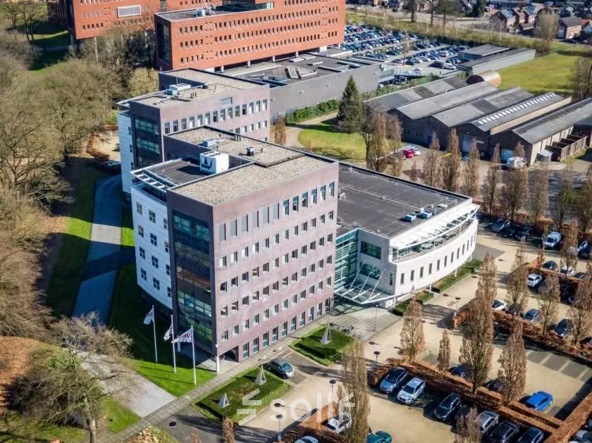 Aerial view of an office complex at Schumanpark 9, Apeldoorn, showcasing multiple modern buildings available for office space rental.