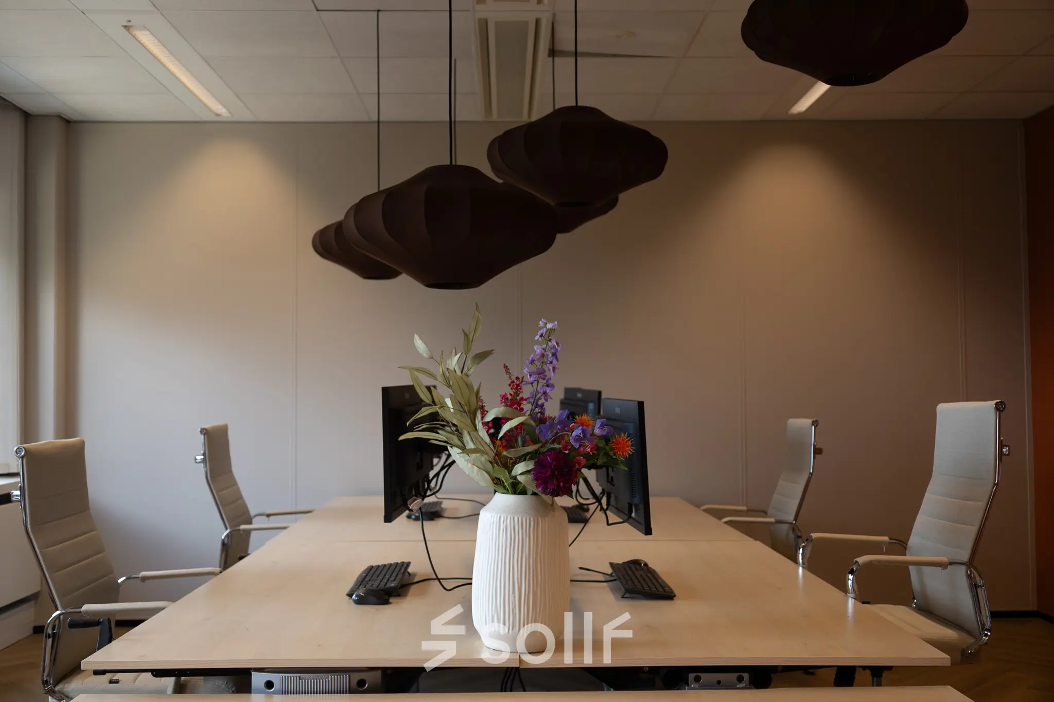 Bright office space with a central table and chairs, ideal for office space rental at Schumanpark 9, Apeldoorn.