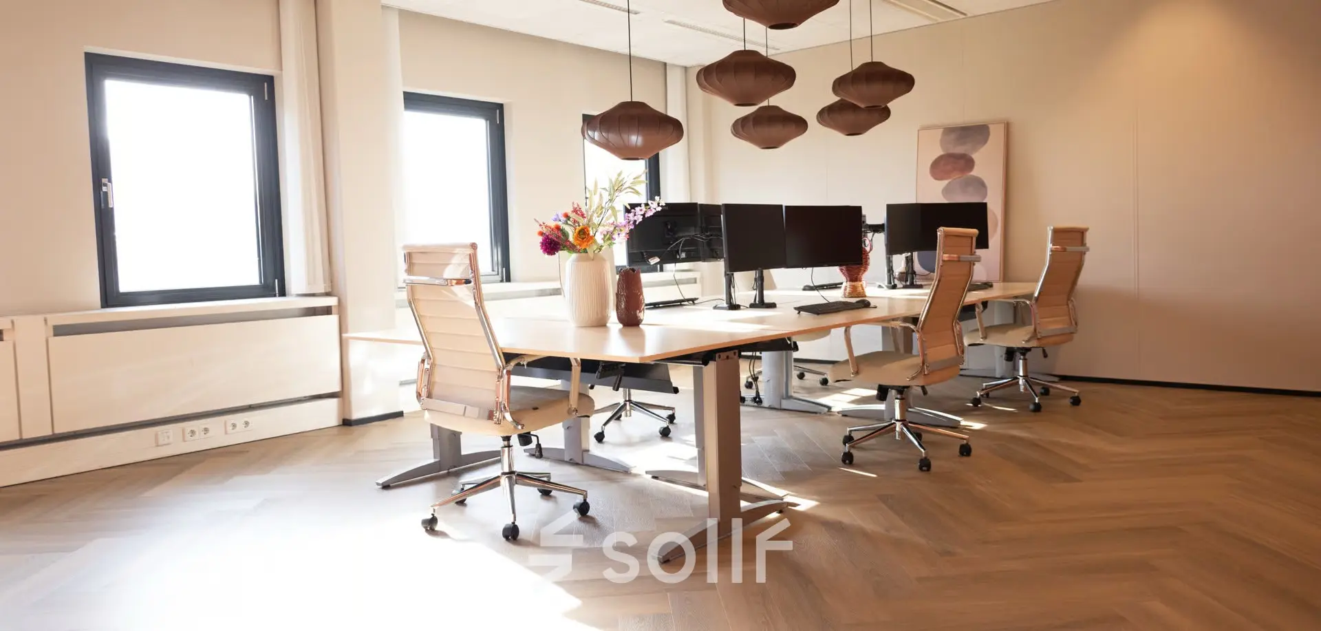 Bright, furnished office space at Schumanpark 9, Apeldoorn, featuring a modern design with workstations and stylish lighting, ideal for office space rental.