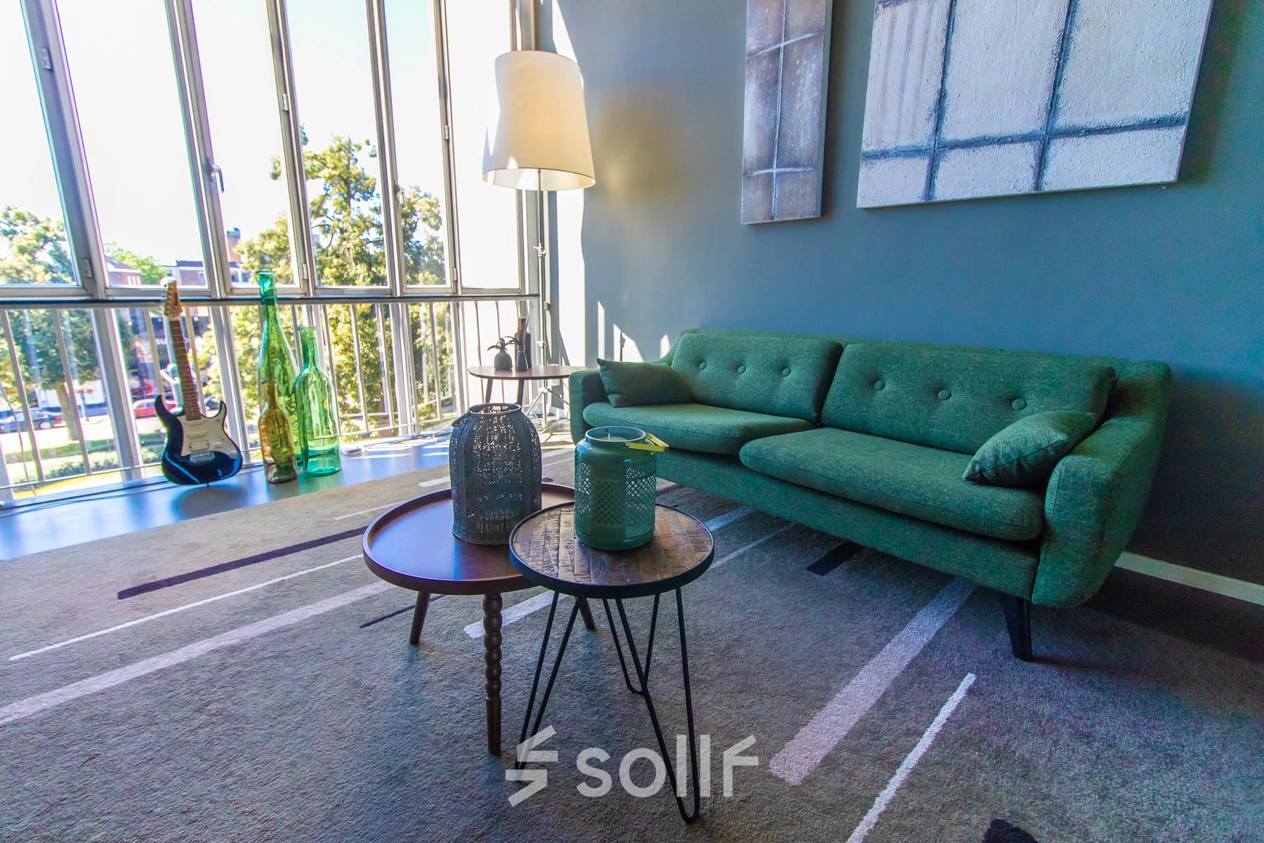 Cozy office lounge at Jansbuitensingel 7, Arnhem Centrum, ideal for office space rental, featuring plush seating and large windows with a view.