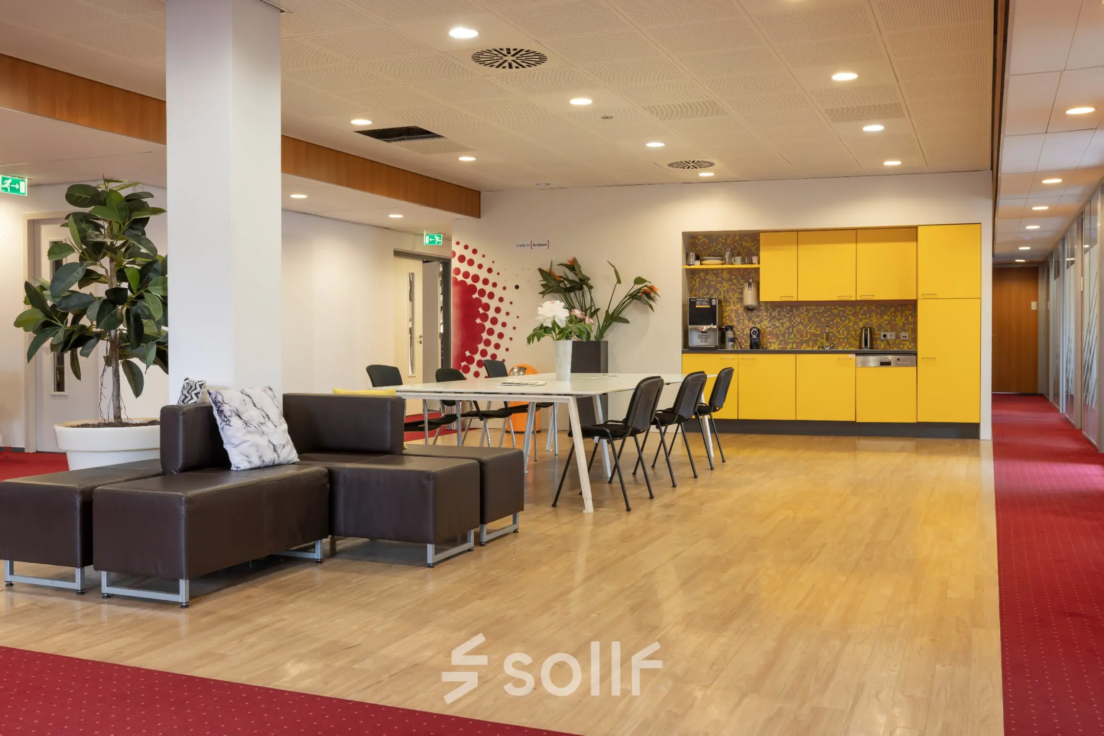 Open floorplan at Kronenburgsingel 525 in Arnhem Zuid, featuring a furnished seating area and colorful kitchenette, ideal for office space rental.