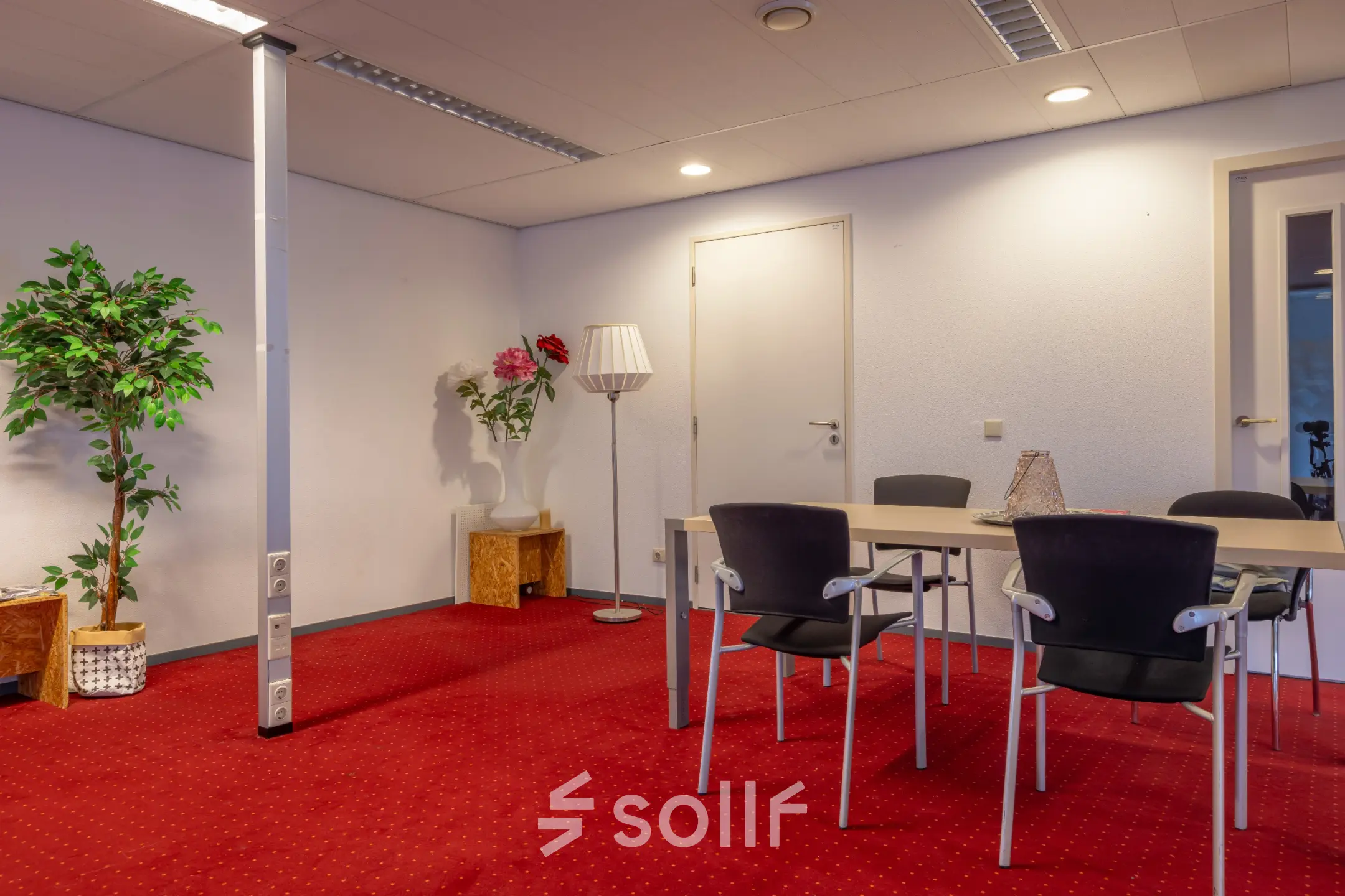 Furnished office space at Kronenburgsingel 525, Arnhem Zuid, featuring a table and chairs on a red carpet.