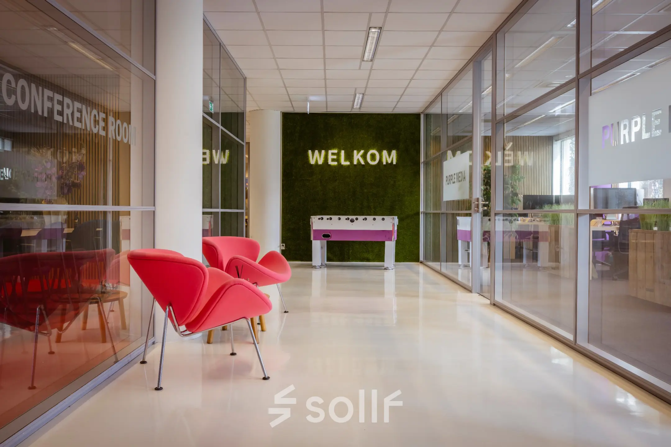 Modern office to rent at Amalialaan 126, Baarn, featuring a bright entrance area with red chairs and frosted glass conference room.