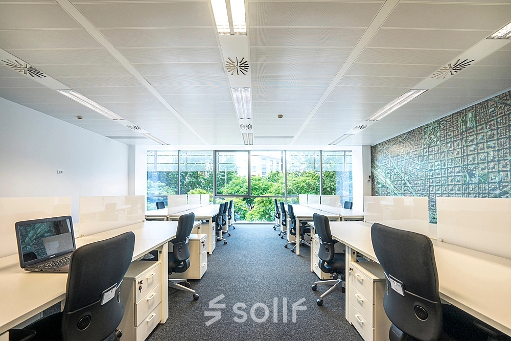 Bright, well-lit office space with rows of desks and ergonomic chairs, ideal for office space rental at Carrer de Llull 321, Barcelona @22.