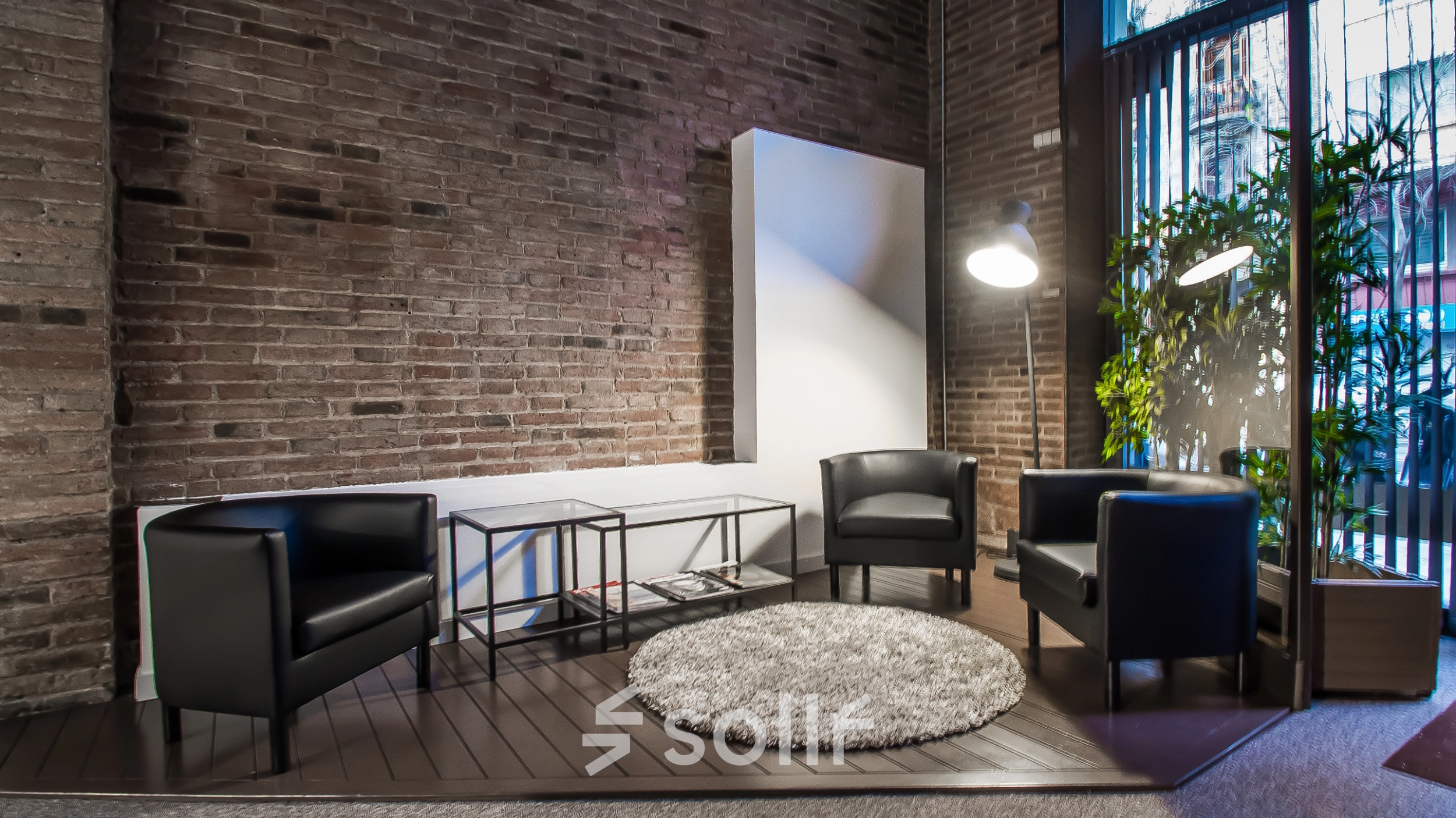Inviting office space with modern furnishing, including three black chairs and a round rug, located in Barcelona Eixample. Ideal for office space rental with a touch of style.