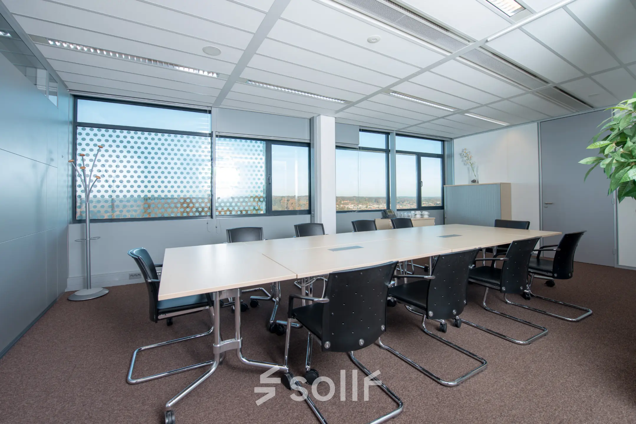 Spacious conference room at Carrer de la Marina 16-18, Barcelona Sant Martí, featuring a long table with black chairs, ideal for office space rental.