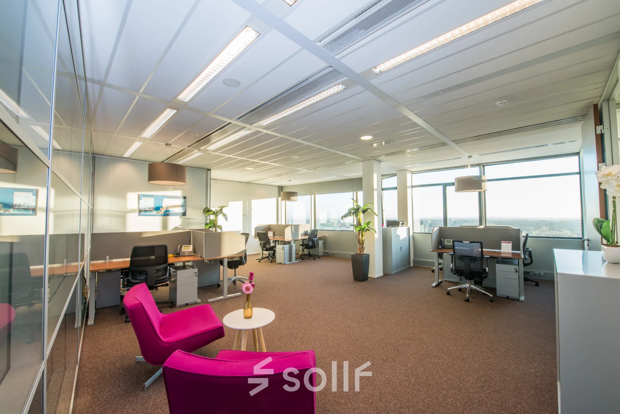 Spacious and bright office at Carrer de la Marina 16-18, Barcelona Sant Martí with several workstations, modern furnishings, and large windows offering city views, ideal for office space rental.
