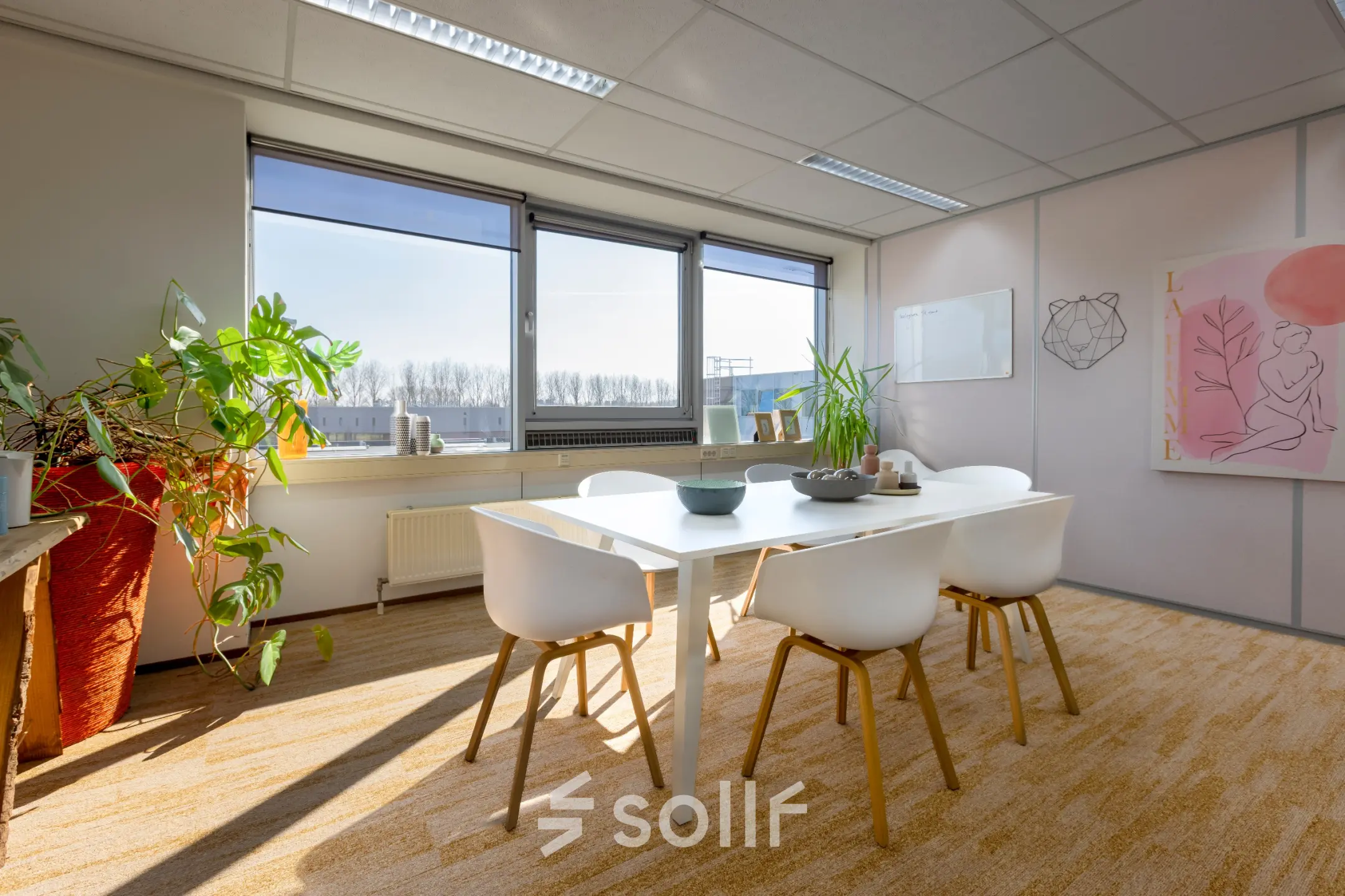 Bright office space with a table and chairs, adorned with plants and modern artwork, at Kamerlingh Onnesweg 10, ideal for office space rental in Barendrecht.