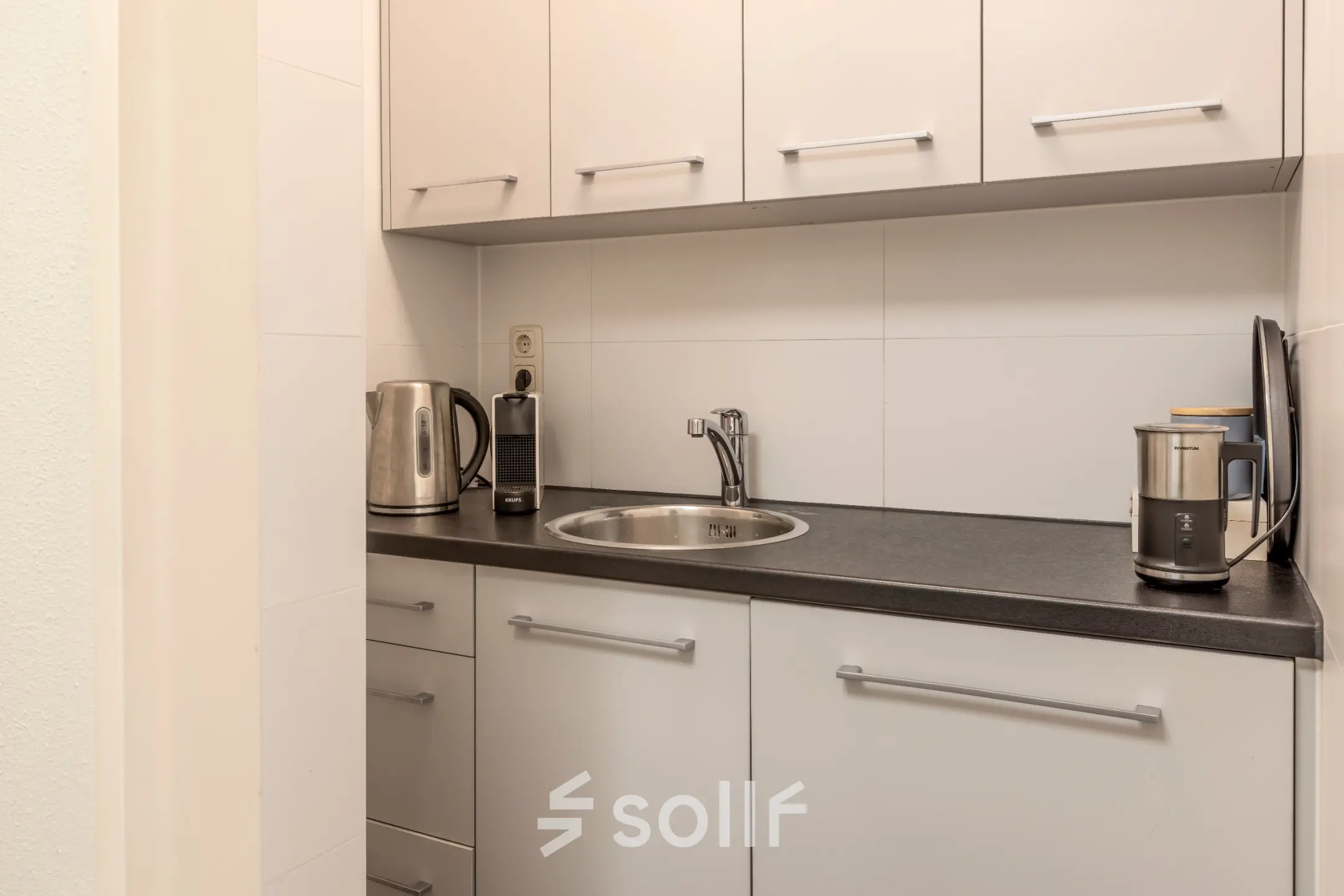 Compact kitchenette with a sink, cabinets, and countertop appliances, ideal for office space rental at Kamerlingh Onnesweg 10, Barendrecht.