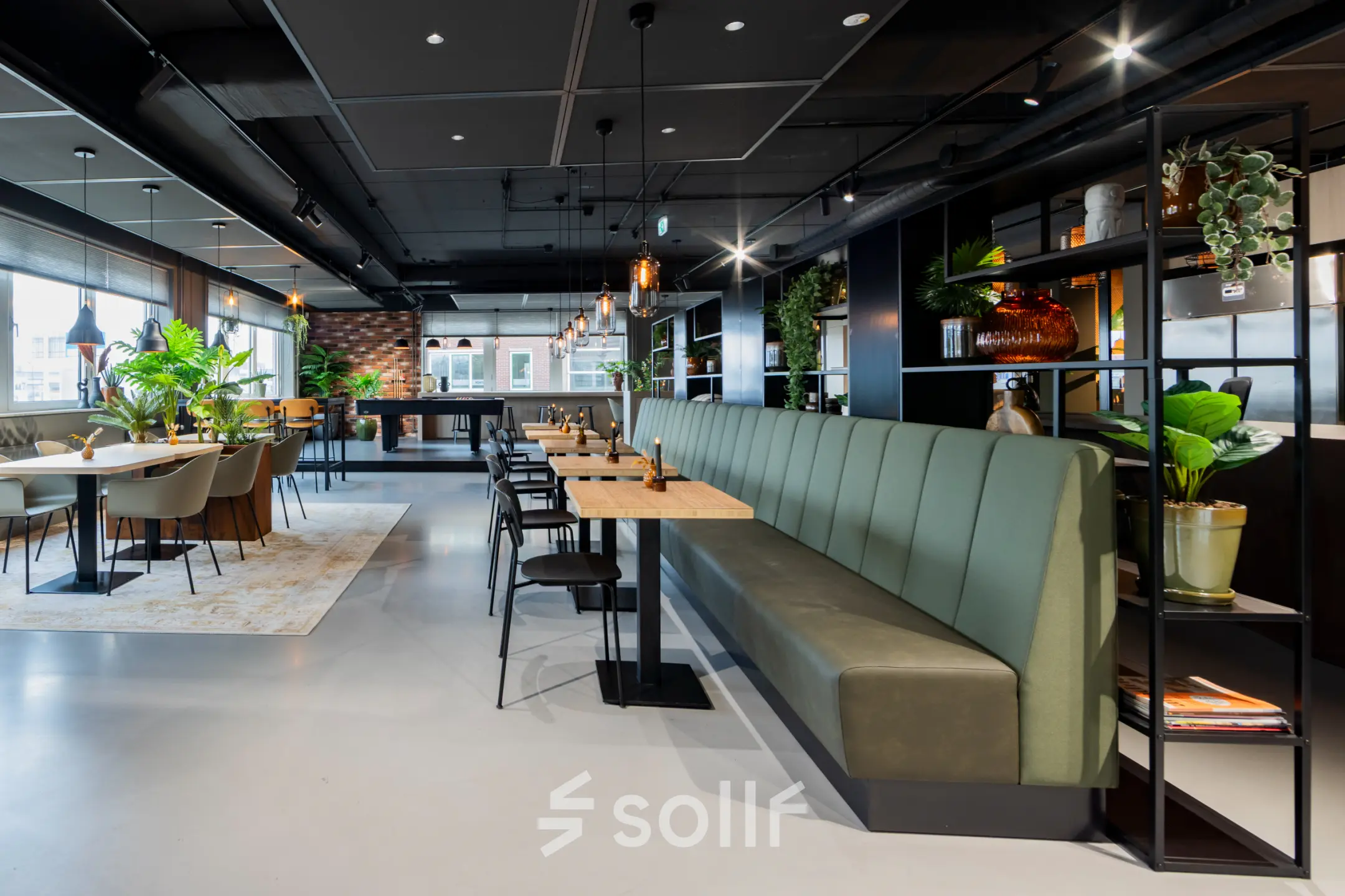 Modern office space with stylish furnishings, featuring a long green bench and tables, available for rent at Baron van Nagellstraat 136 in Barneveld.