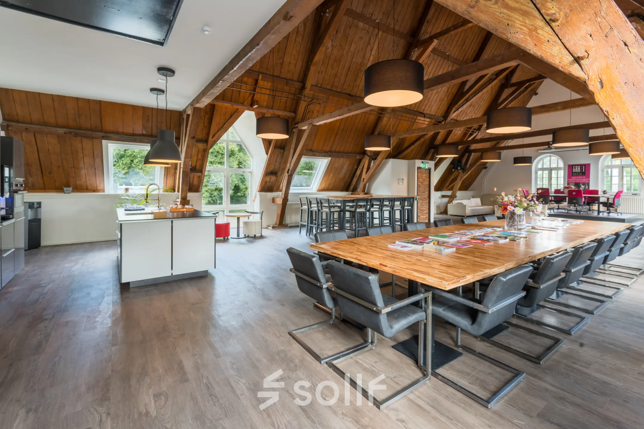 Spacious office at Blokstallen 2B, Bergen op Zoom with wooden beams, modern furnishings, large tables, and ample natural light, ideal for office space rental.