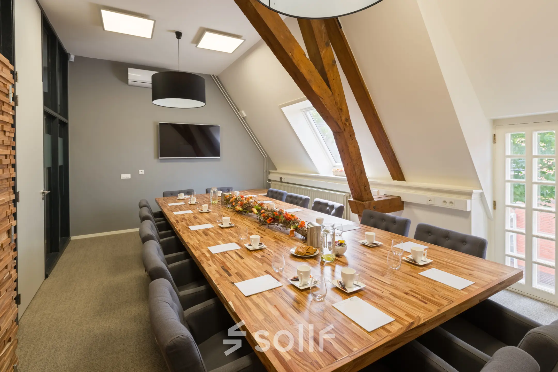 Modern office meeting room at Blokstallen 2B in Bergen op Zoom, featuring a large wooden conference table, comfortable chairs, and bright lighting, ideal for office space rental.